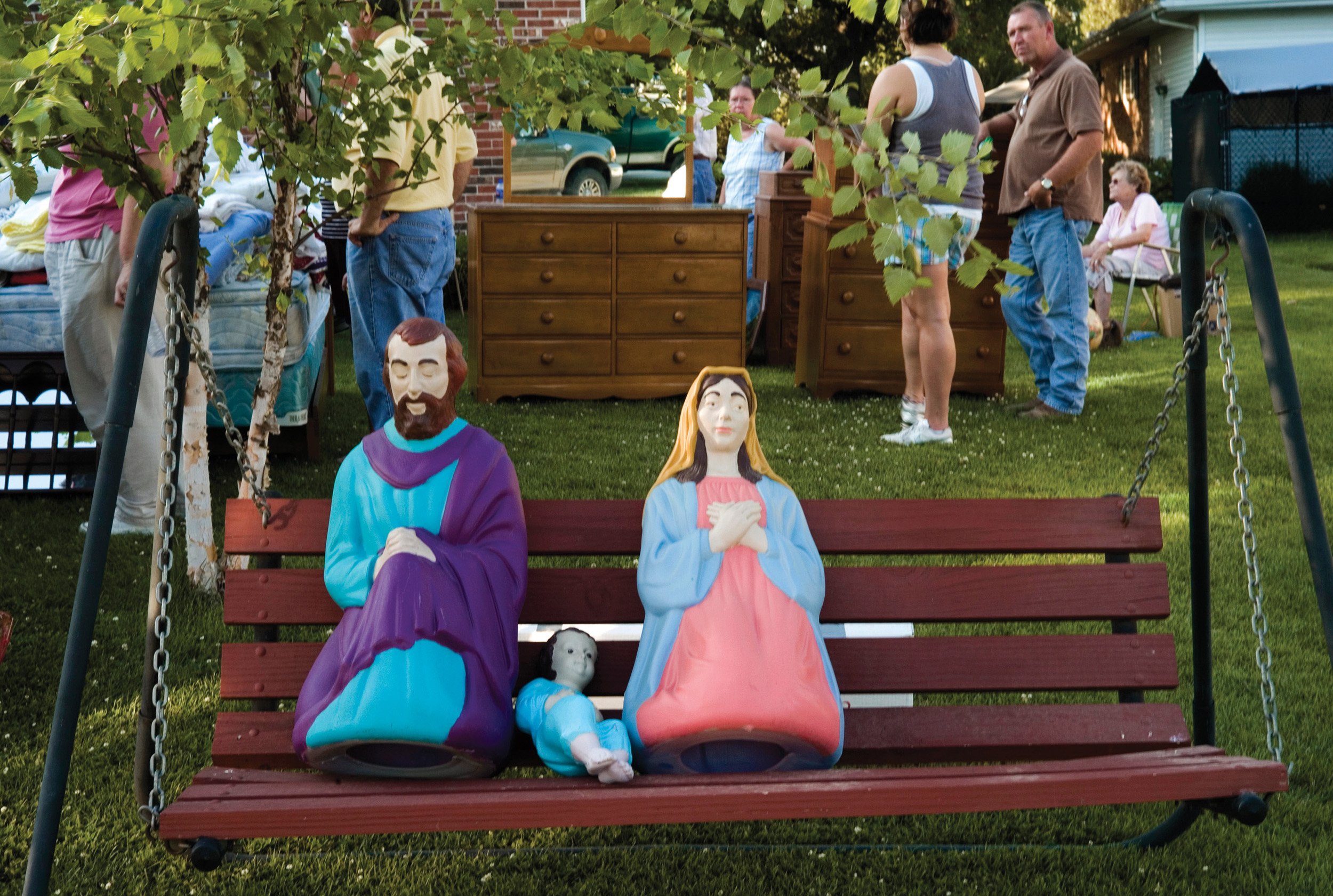  Plastic statues of Joseph, baby Jesus and Mary set on a swing set at an auction. Rushville, IL. June, 2009  