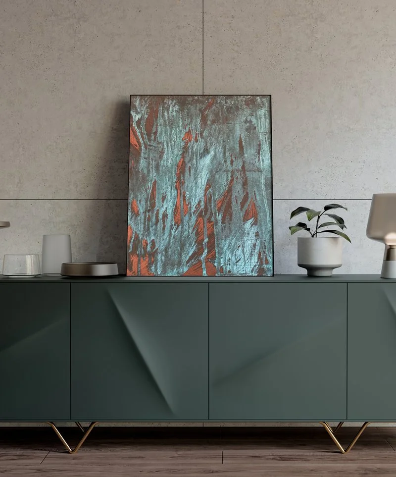 A modern sideboard with decorative items including a painting, a plant in a white pot, and various small objects, against a textured wall.