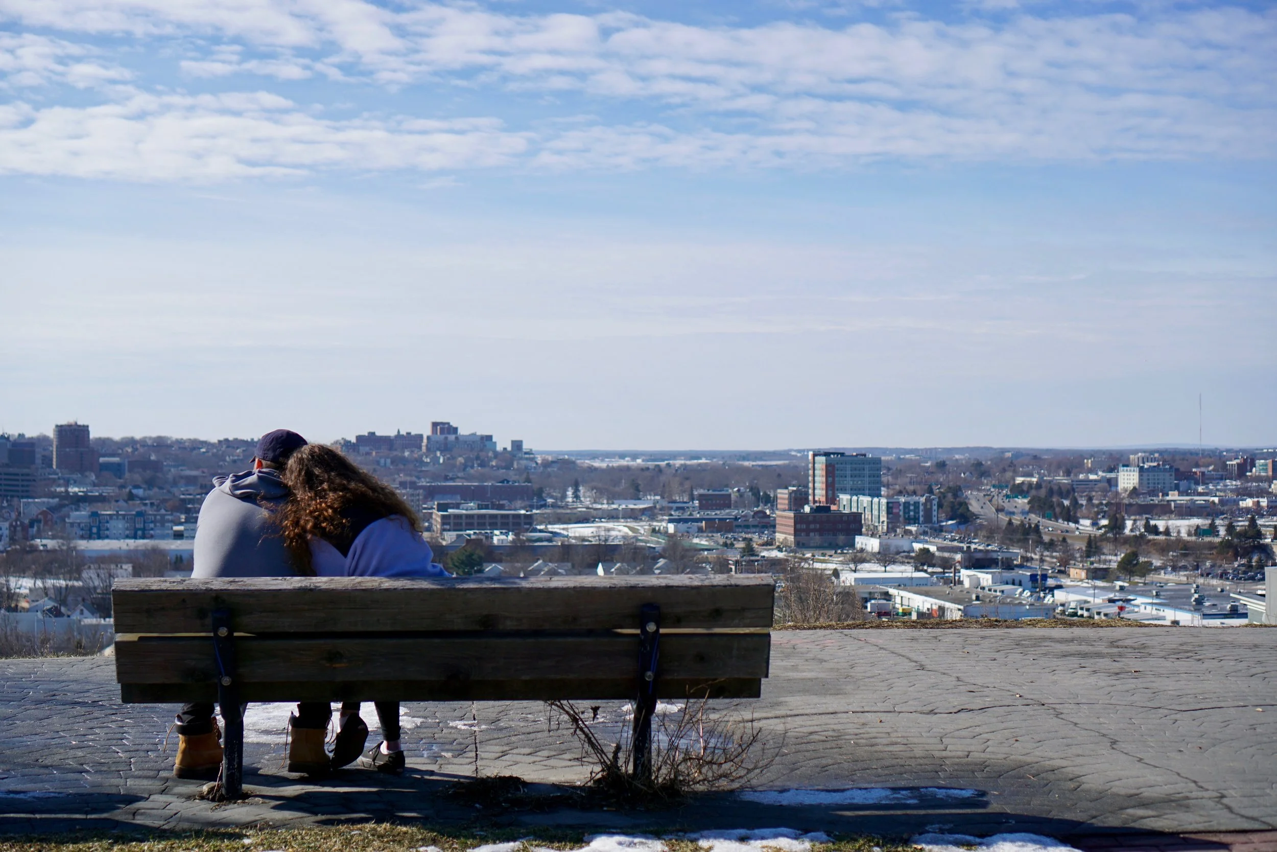 A couple enjoys a winter break atop Munjoy Hill, taking in the view from Ft. Sumner Park. A proposed residential development on Sheridan St. would obstruct a large portion of the unique vista.