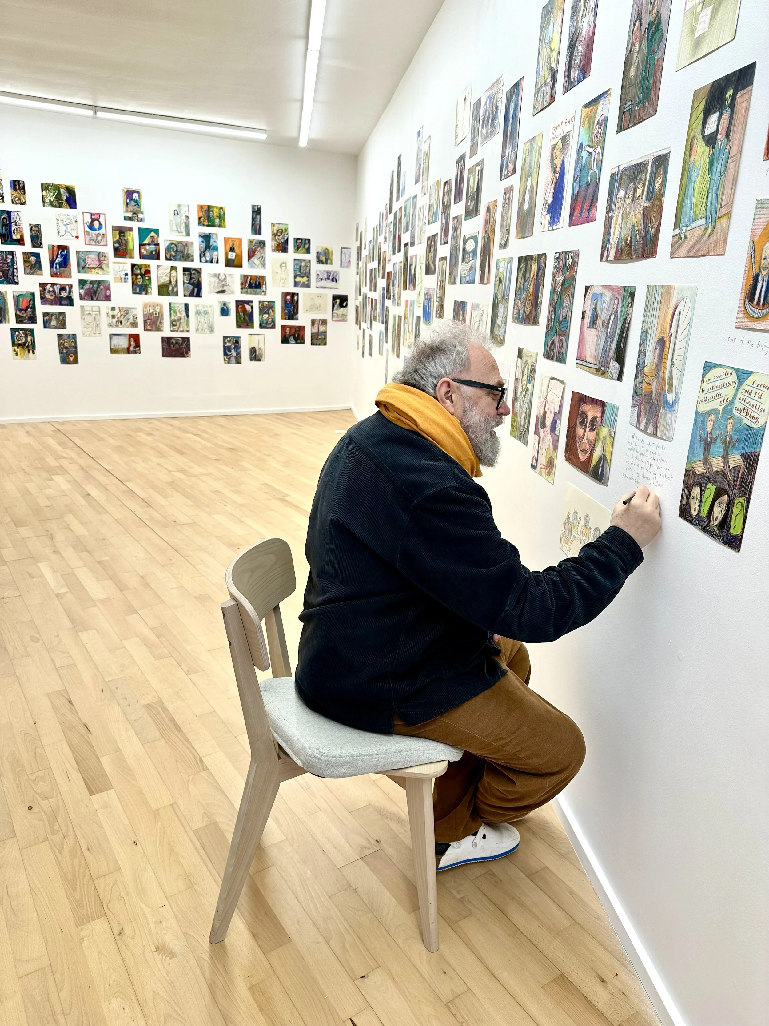 Matthew writing the titles underneath 300 drawings