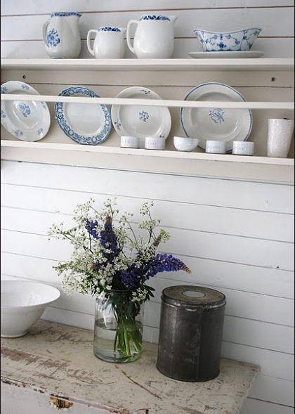 Antique shelves and dinnerware, white plates and jugs filled with greenery via pinterest