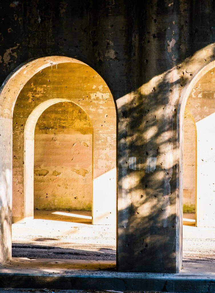 Orange light filters through a series of increasingly dark arches