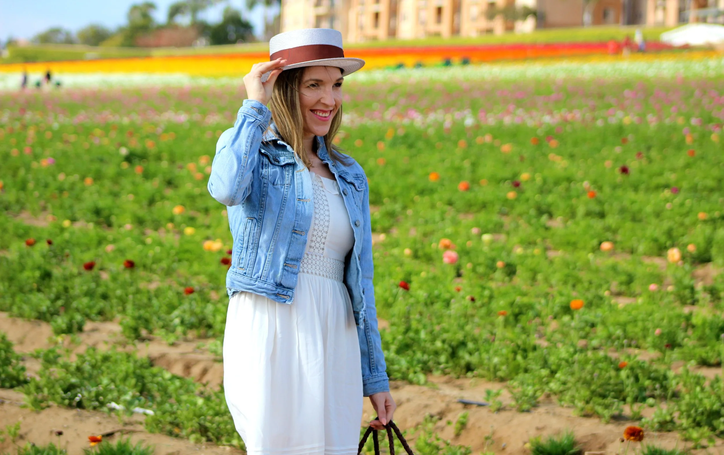 Dress : Loft ( I'm wearing petite) // Jacket : Banana Republic // Bag : Global Goods Partners, similar here // Hat : Goorin Bros // Flats : Banana Republic ** Warning: Picture and talking about my love for flowers overload in this post! Even though it is Monday, I could care less! I am still feeling the high from my amazing weekend! I know I say it time and time again but I love color and I love flowers! So I could not have been happier going to a place with an immense amount of both! Just looking at these pictures, you can see how breathtakingly beautiful The Flower Fields are. If you are from Southern California or find your way near Carlsbad before May 31st, make sure you stop by. The flowers die off at the end of Spring, so make sure you go soon if you want to partake in the all of the color and floral fun! This white dress is so beautiful, I may have went photo crazy showing it off! You know a dress is a winner if it has twirling capabilities and this one did not disappoint! I love everything about this dress from the soft cream color to the intricate details like the lace and the ruffled cold shoulder. It is definitely a winner for Spring, but would be a great dress to transition into summertime too! If you are looking for other white dresses, I have found similar ones here and here. You really can never go wrong with a white dress in your closet. It is timeless and will always look great for the warmer months of the year! The other details of this outfit like this Goorin Brothers hat or this Global Goods Partners bag just sealed the Spring-ness of this look. The lavender of the hat and the basket weaving of the tote, are great little details for Spring. And because it was a little windy, I had to throw on my denim jacket every once in a while! This look honestly has to be one of my favorites, not only because it was worn with all of the flowers, but because it is effortless while looking so put together and thought out! I hope you all have something that makes you as happy as these flowers make me! I can not wait to go back and see the flower fields next Spring. I am pretty sure this will be my new favorite Spring tradition! Have a great Monday friends! ~ Nicole