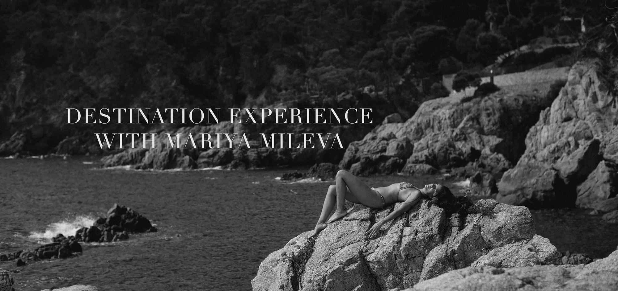 A woman in a bikini lying on a large rock by the ocean, with cliffs in the background. The image is black and white. The text overlay reads 'Destination Experience with Mariya Mileva'.