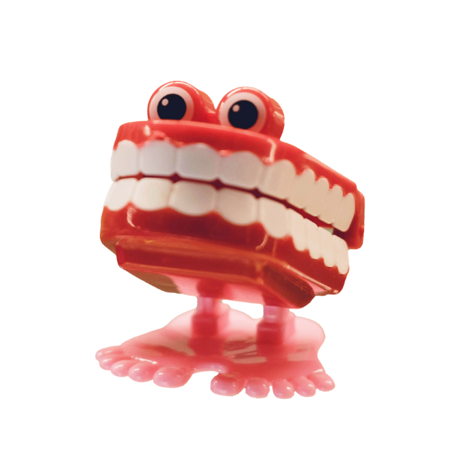 A small red toy that looks like teeth with eyes