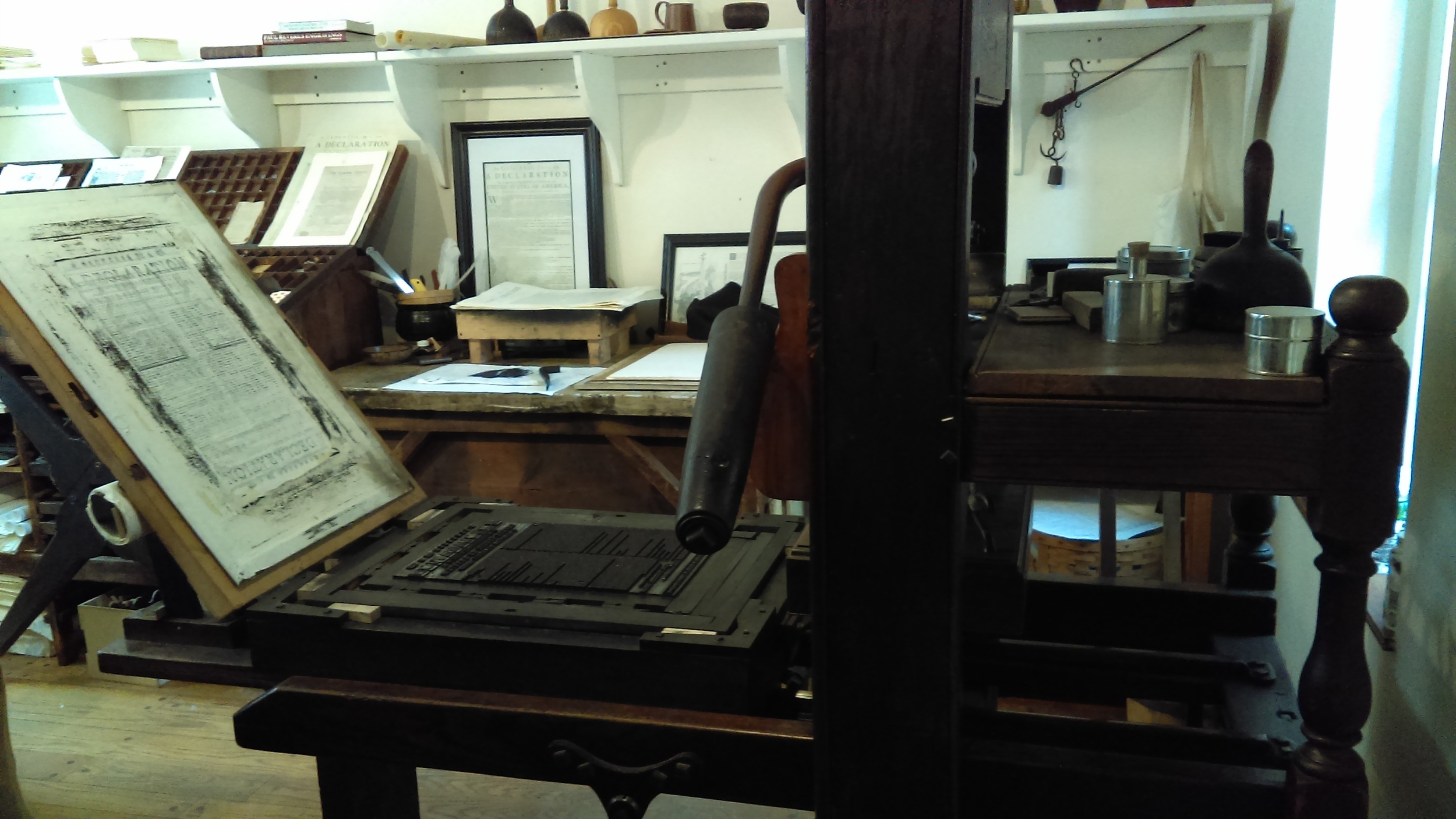 Behind the printing press you’ll see a case which houses all the letters for type, that are arranged, not alphabetically, but by popularity; the most popular being in the center. This case is also the source of our terms ‘uppercase’ and ‘lowercase’. The uppercase letters having been stored in the top case and the lowercase letters in the bottom. The printer would set the type without looking at the letters, trusting that the apprentice placed them correctly and feeling for a nick, which allowed him to place correctly into the form; upside and backwards.