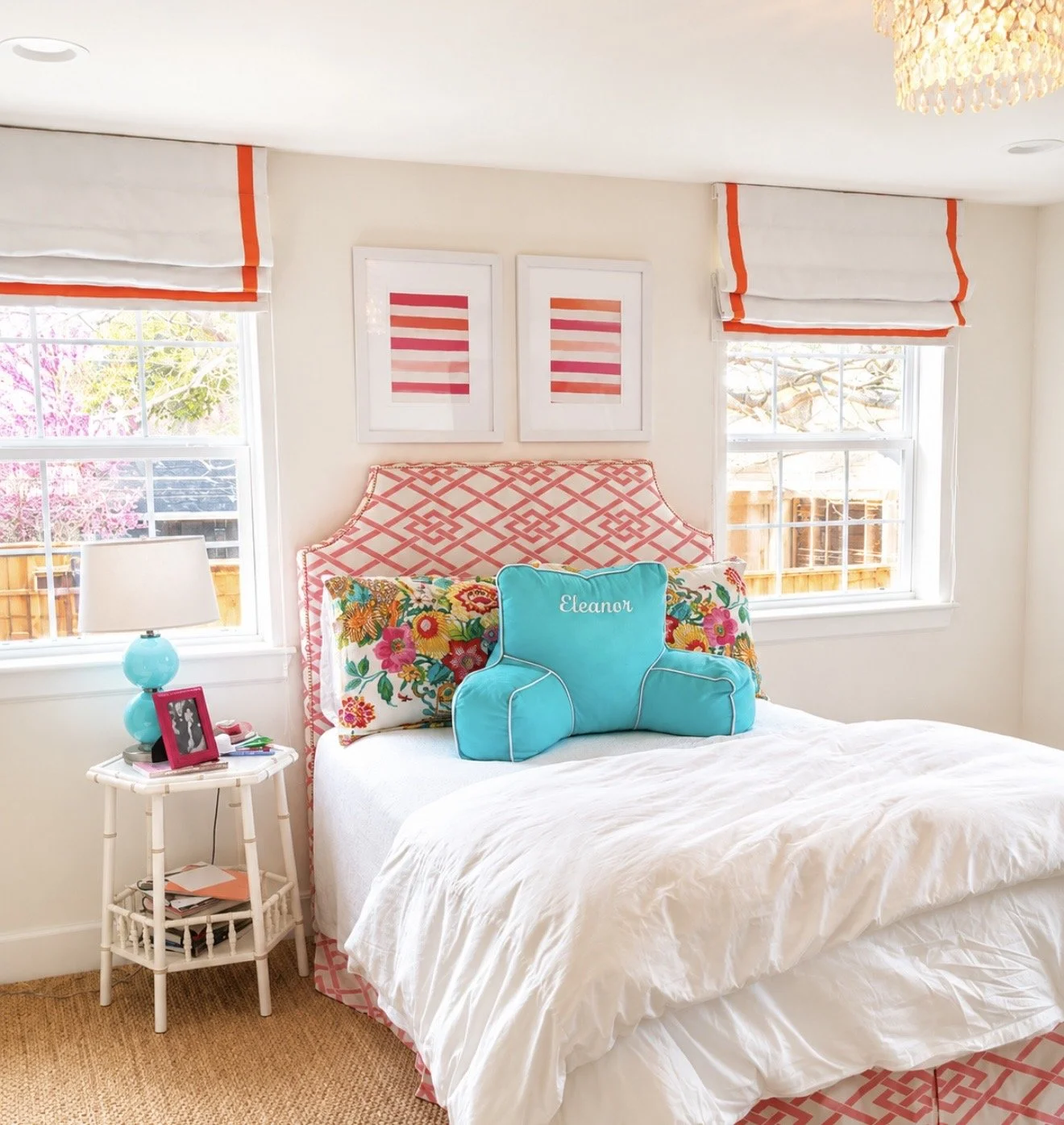 white canvas roman shade with orange ribbon added in a bedroom