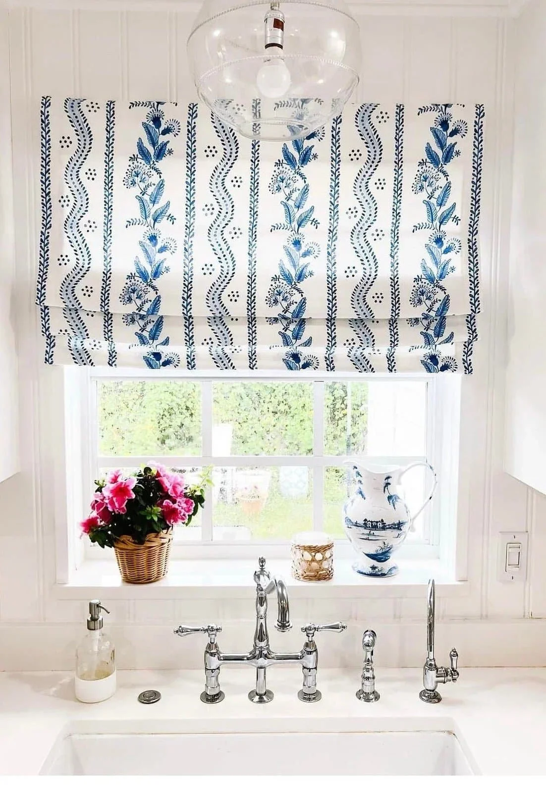 blue floral roman shade in a kitchen window