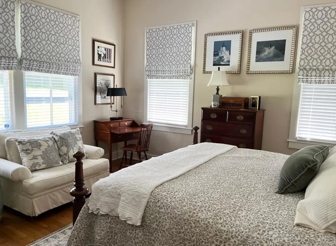 grey roman shades in a bedroom window