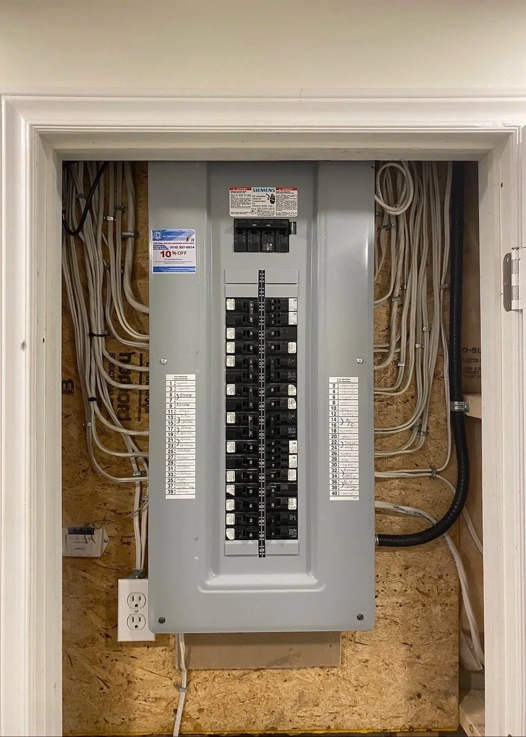 Finished residential electrical project showing a Siemens circuit breaker box installed in a utility wall space.