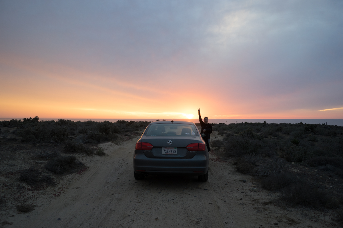 Cynthia somewhere between Ensenada and El Rosario, where we pulled the car over and ran down a dirt road to catch the sun set over the ocean.