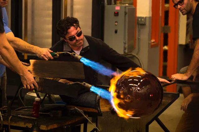 John Kiley, creating perfect orbs and curves, the first segment of his process, with his team in the Hot Shop.