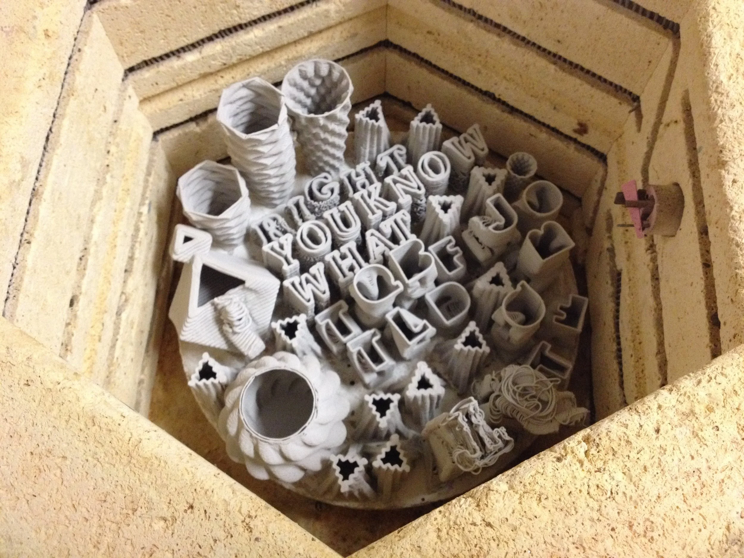 A mix of objects–3D printed ceramic objects and Type emerge from the Kiln after being baked by Taekyeom Lee.