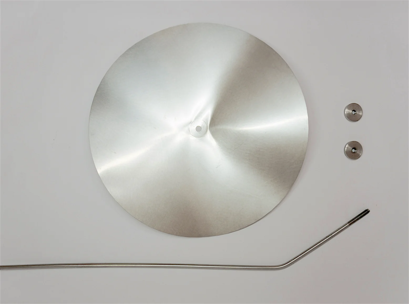 The components of a Rain Flower-Bent circular metal disc, stainless steel stem, nuts and bolts-created by Jessica Bizzoni