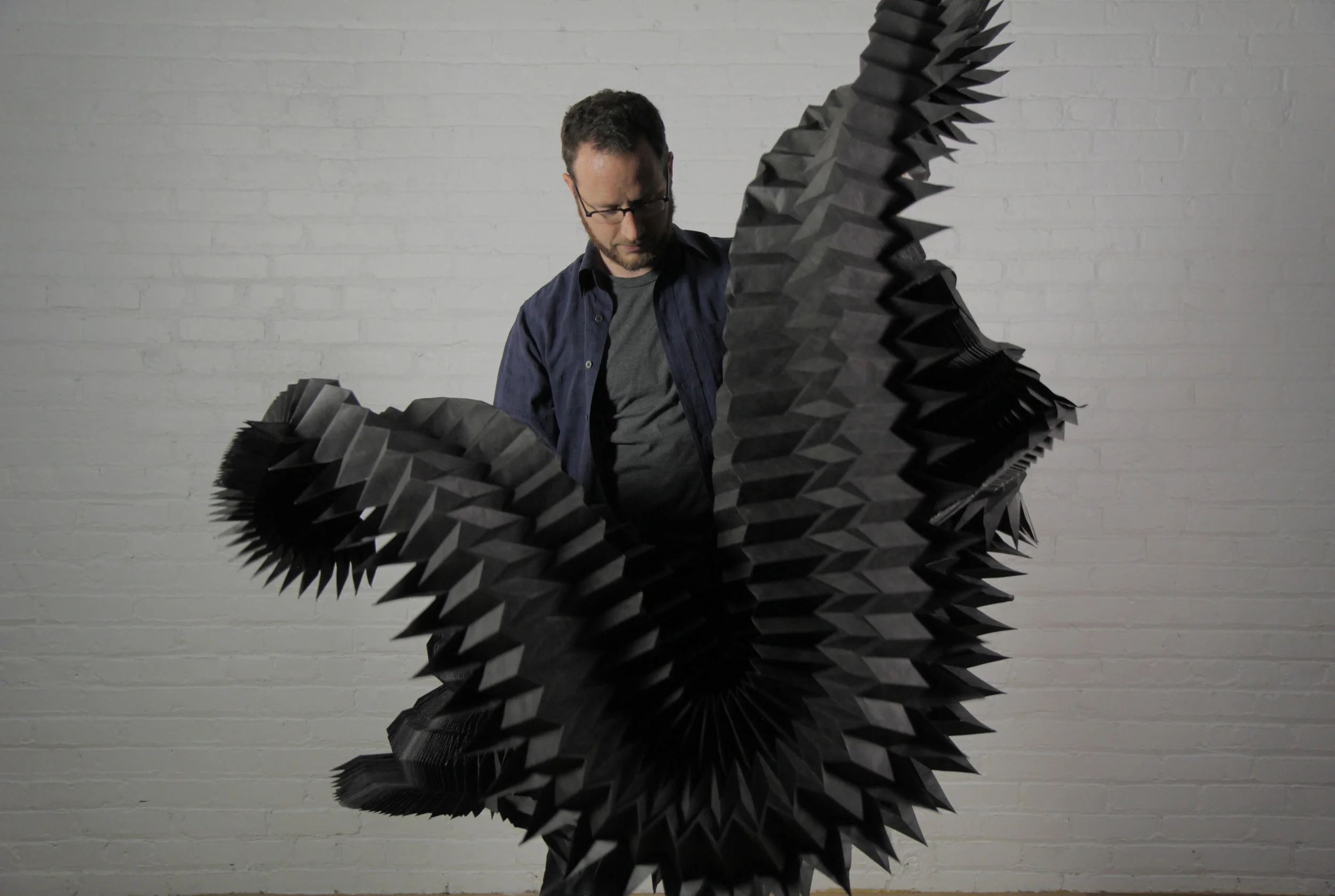 Matthew Shlian, seen here with his work.