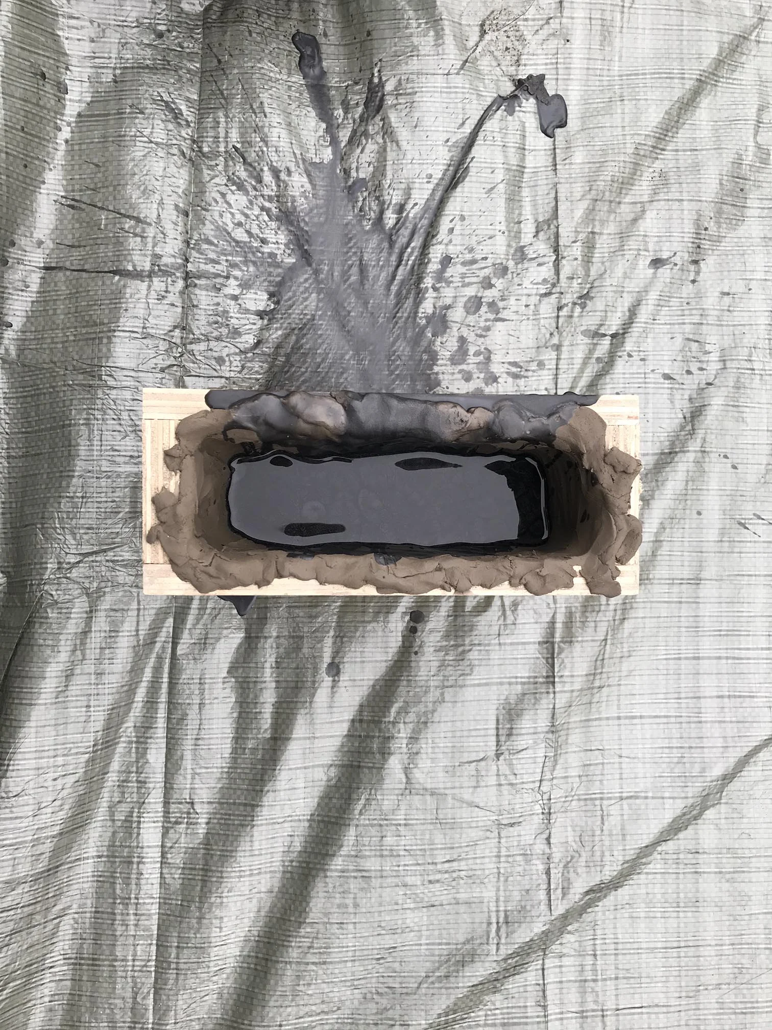 Casting liquid Wax Paraffin and Carbon in a mould of clay, for the Three-Pillar Seat by Ida Elke, created for the Age of Man exhibition, Milan Design Week 2017