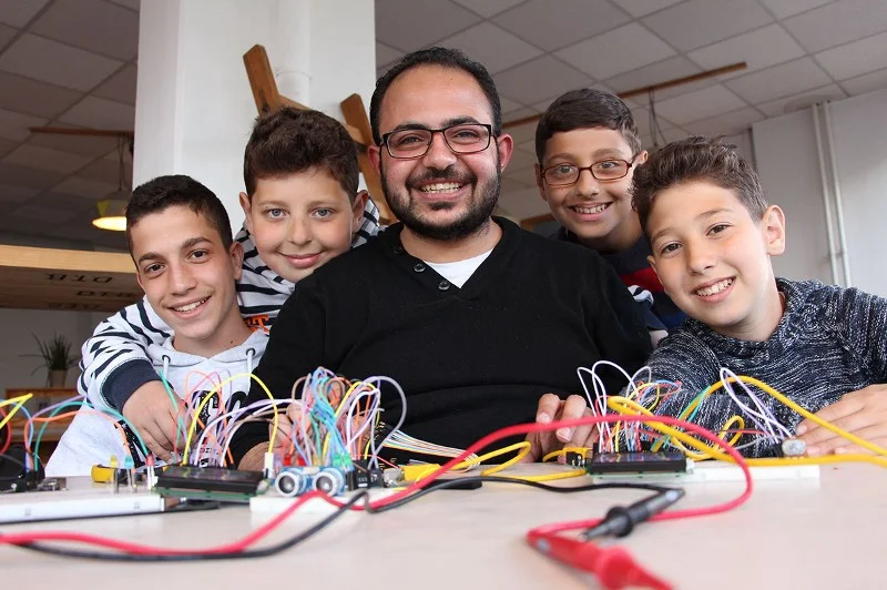 Syrian refugee Asem Hasna and students at his class in Berlin