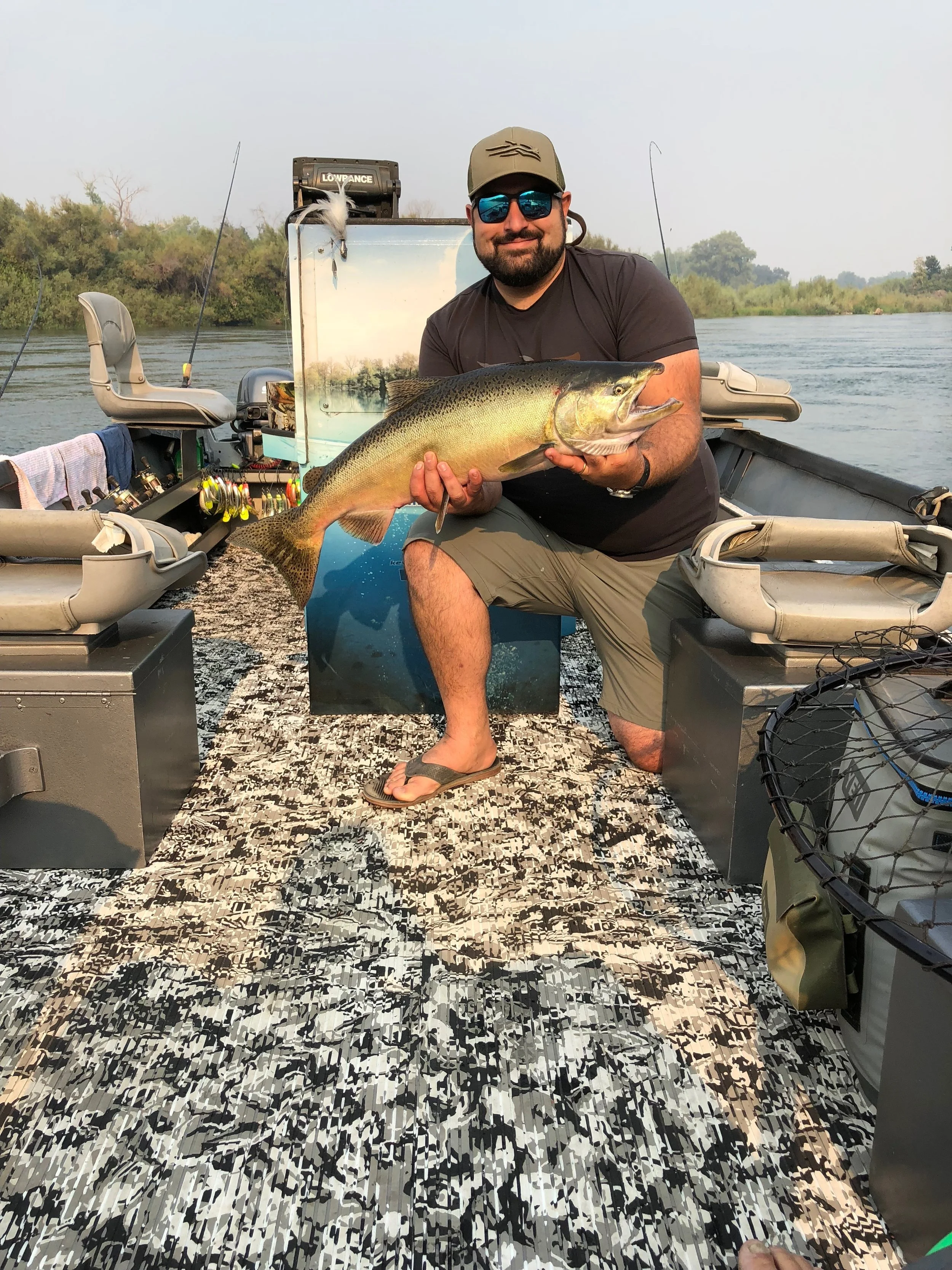 Christopher Tocatlian holds up a Sacramento River salmon he caught while flatlining a T-55 Flatfish from Yakima Bait Co. yakimabait.com&nbsp;. This photo also shows off the new Hydro Turf flooring from Beckley's Boat Works in Colusa, Ca https://www.…