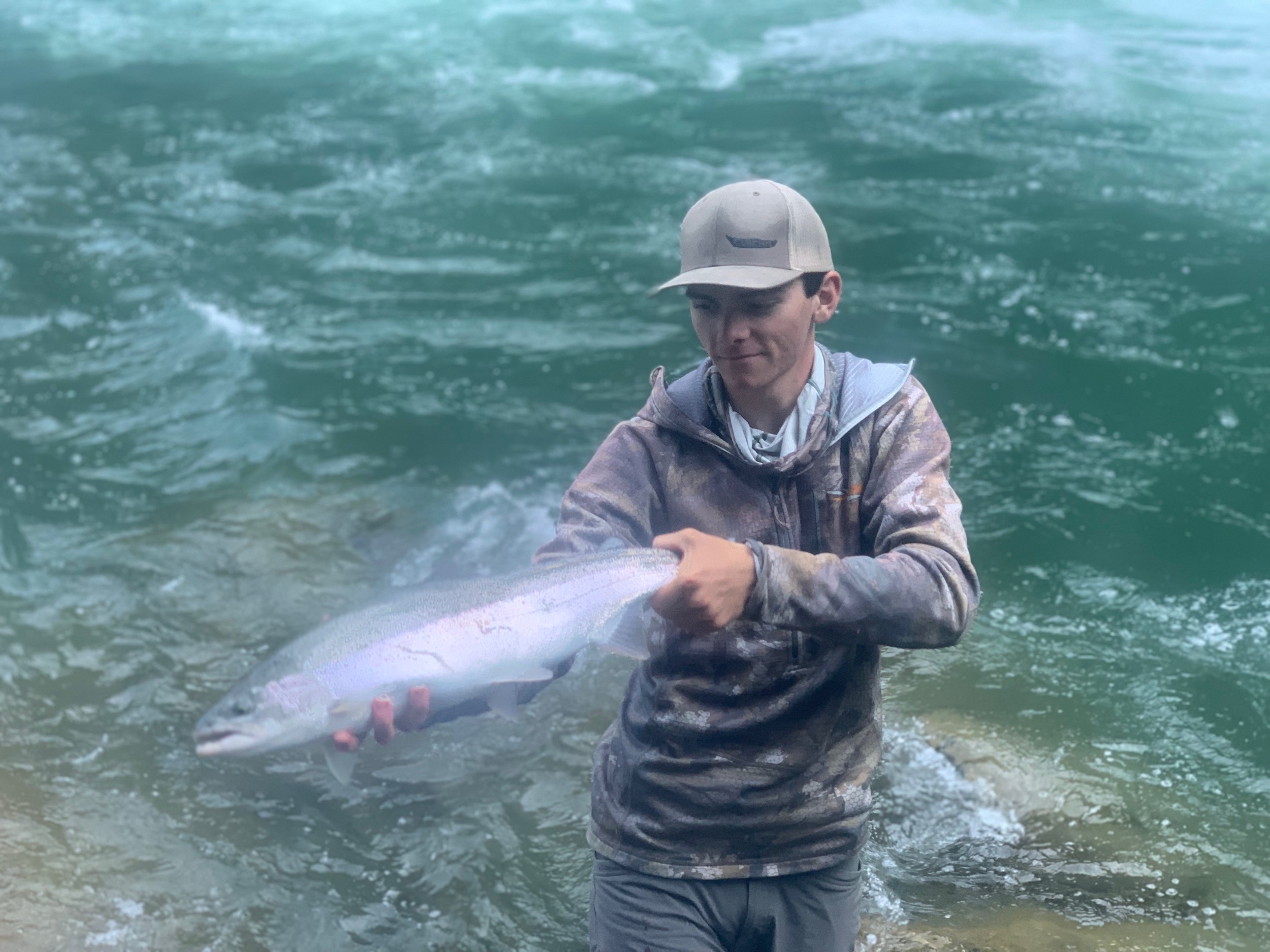 Fishing Guide Ryan Tripp holds up a beautiful wild steelhead he caught while salmon fishing the Trinity River this week. In addition to spring run chinooks, these wild steelhead add extra action for anglers. All wild steelhead must be released!