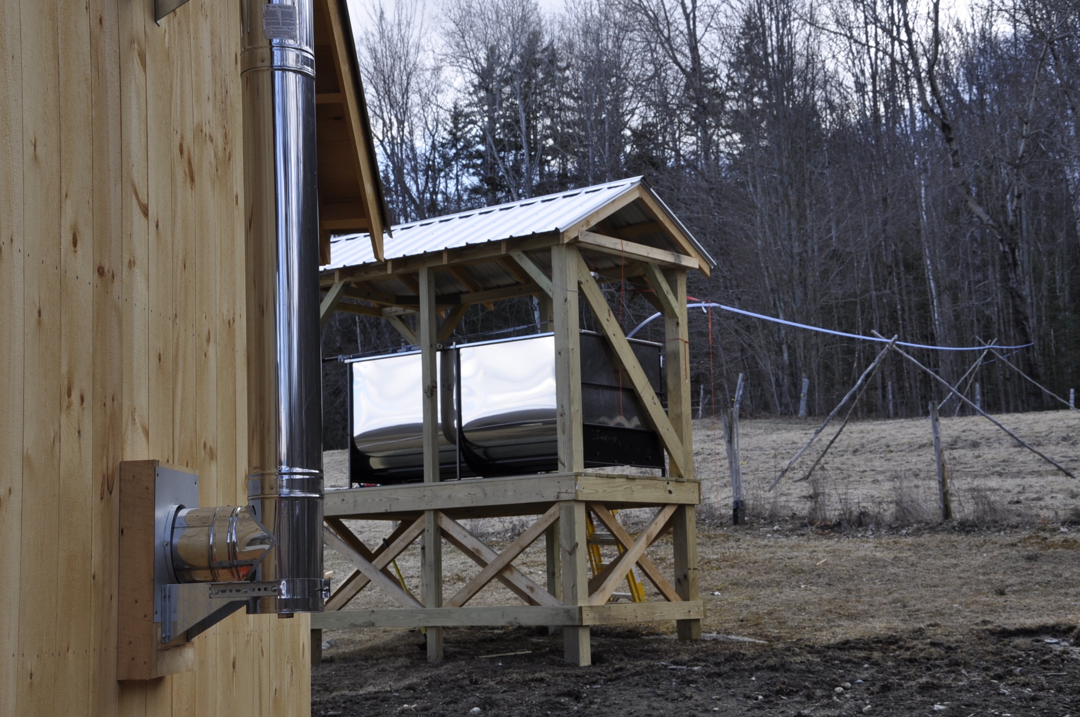 Sap lines run from sugar bush, across pasture and into big stainless tank.