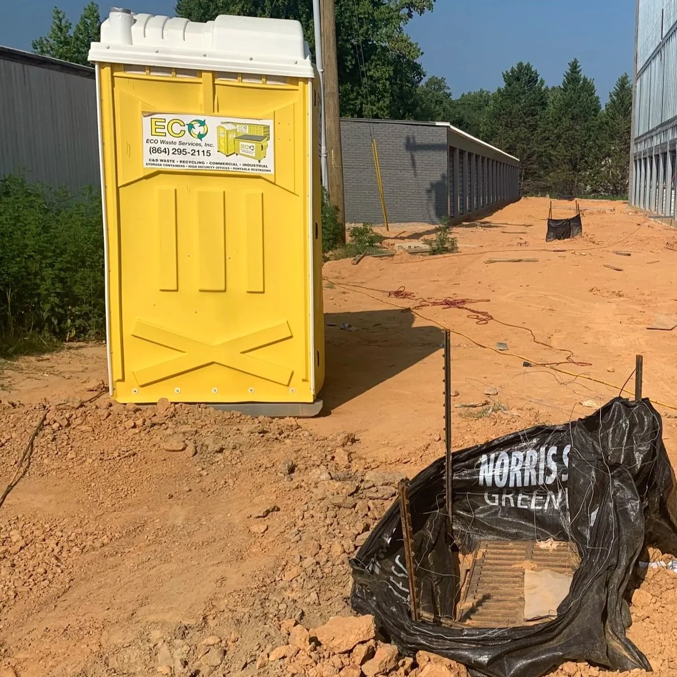Poorly place Port-A-John with damaged silt fence