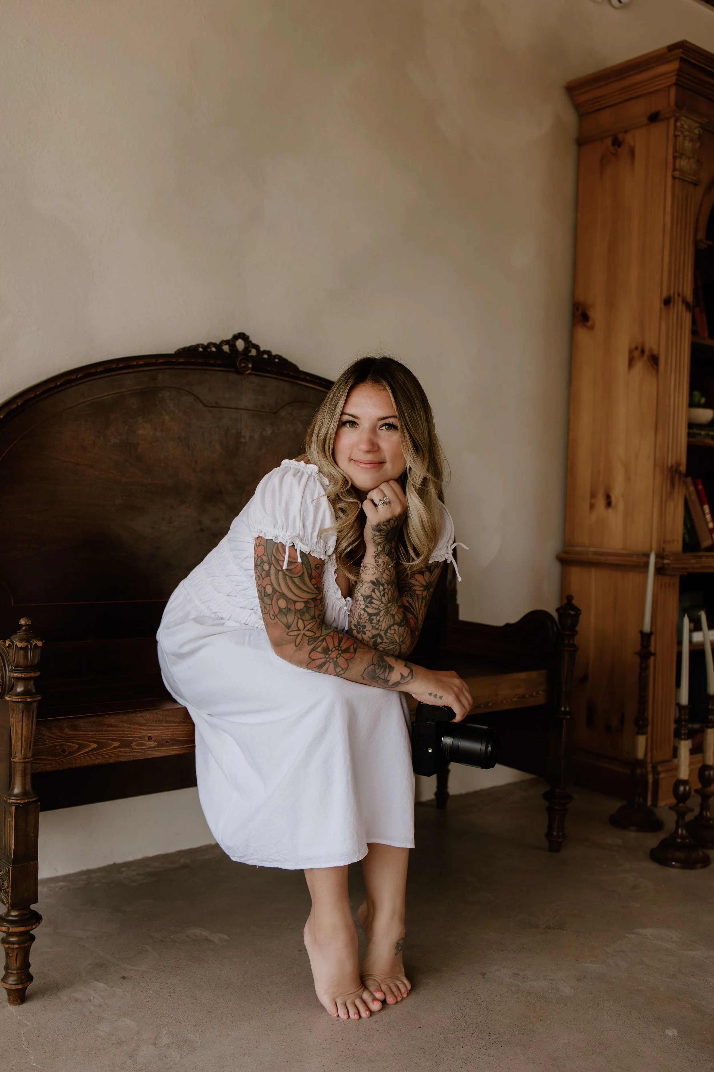 Keri, Owner of Arizona Honey Photography posing on an old antique, brown  bench in Scottsdale Arizona