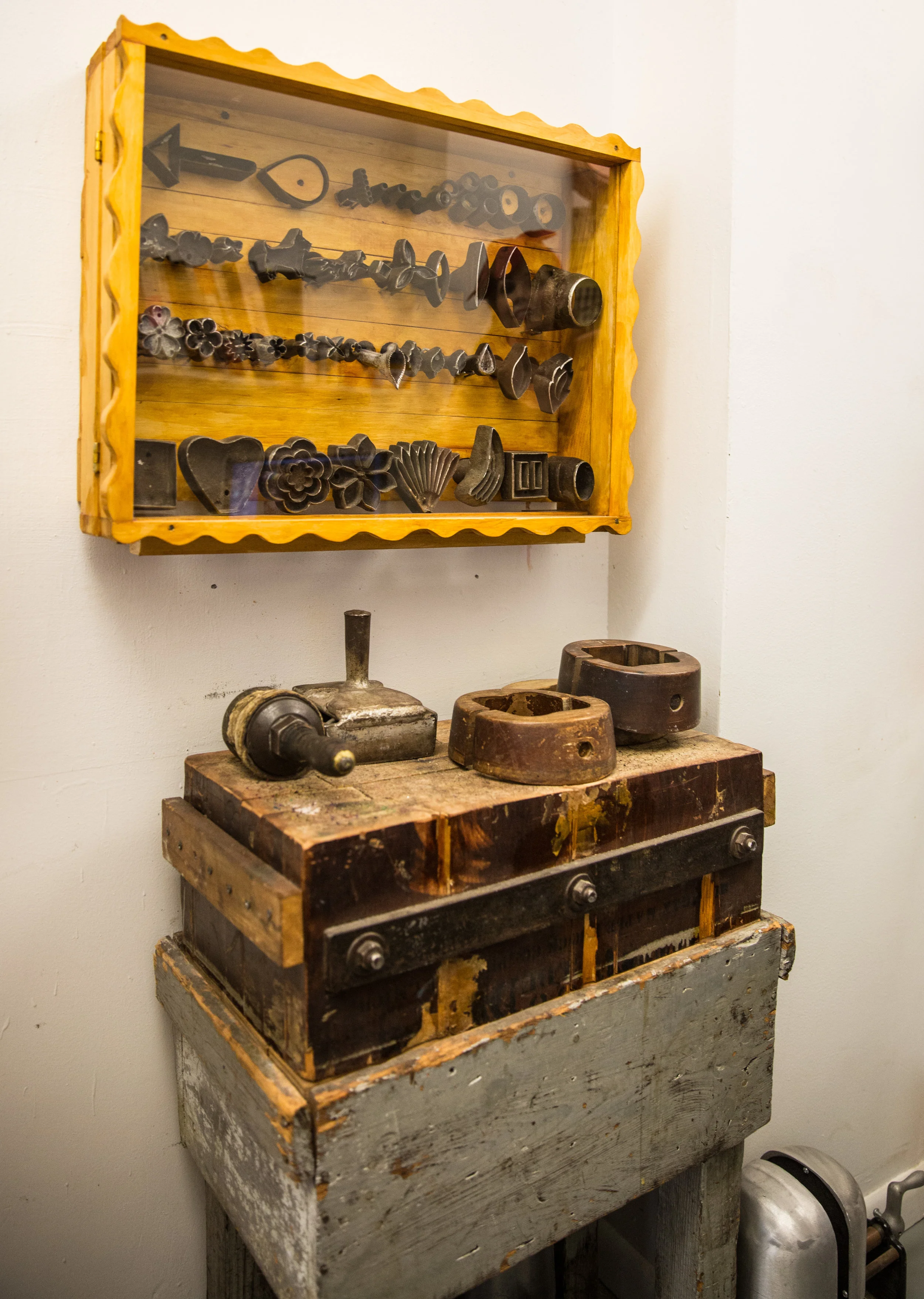  A collection of 100 year old cast iron millinery fabric molds in a case at the Jennifer Ouellette studio. (Benjamin Chasteen/The Epoch Times) 