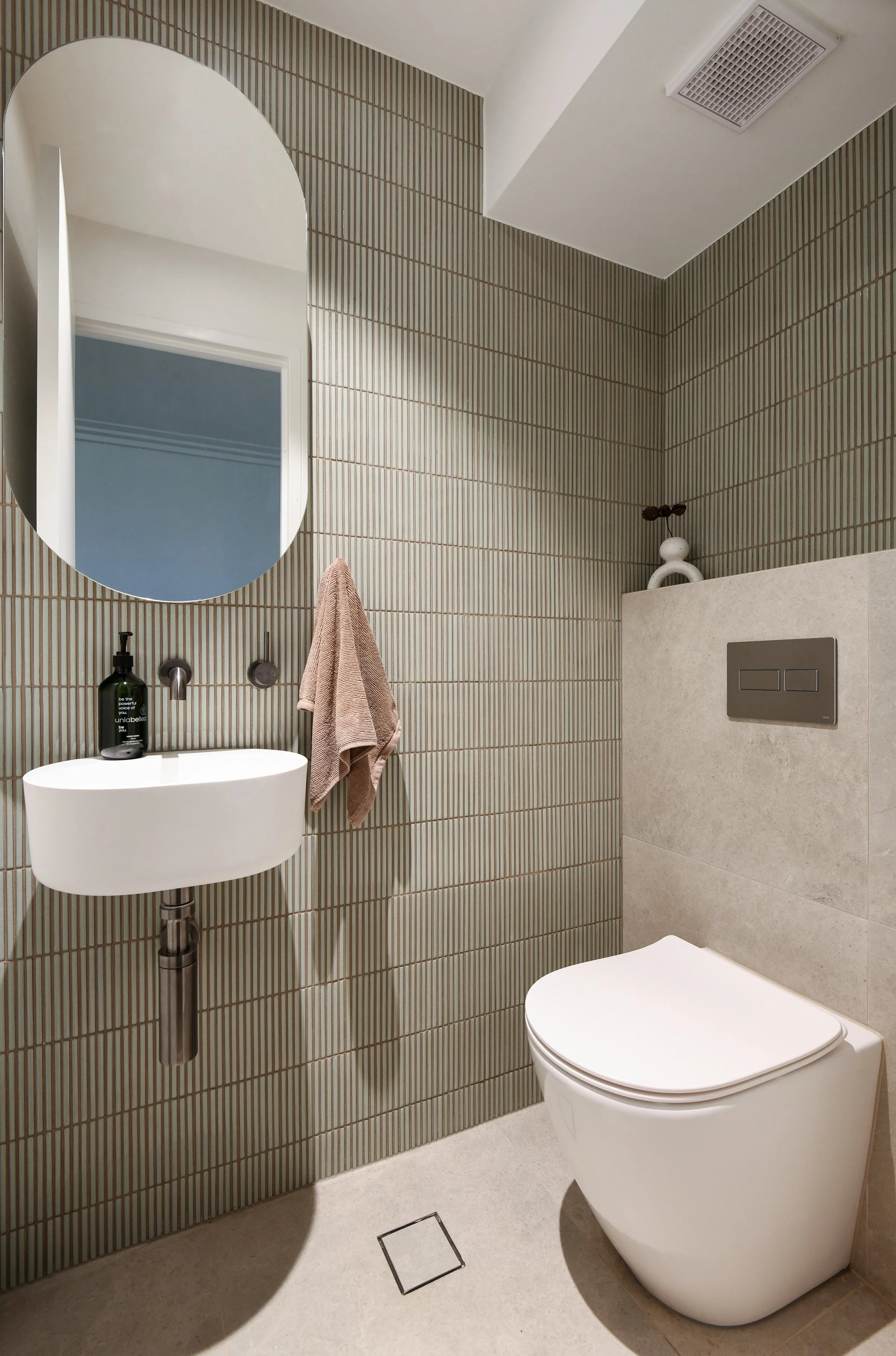 Image of a neutral bathroom with a kitkat feature tile. 
