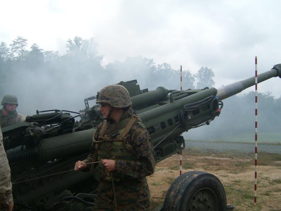 Marine Corps Officer, Sallie Benson about to pull the string that makes the howitzer go “boom.”