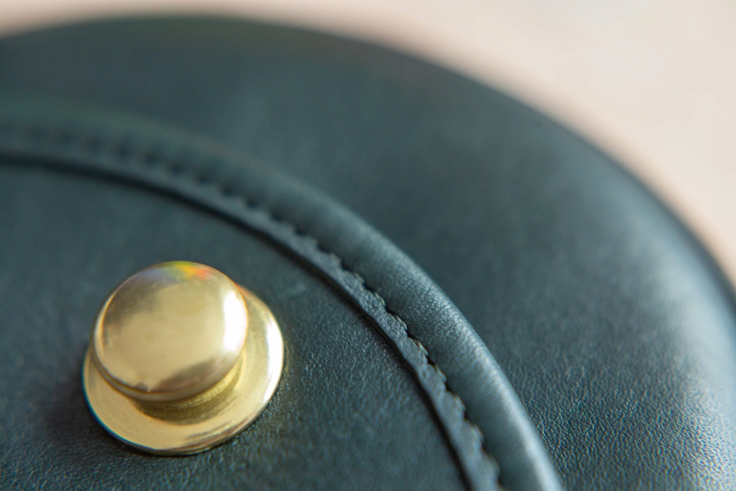 FULL GRAIN glove tanned leather with uncoated solid brass push-button closure