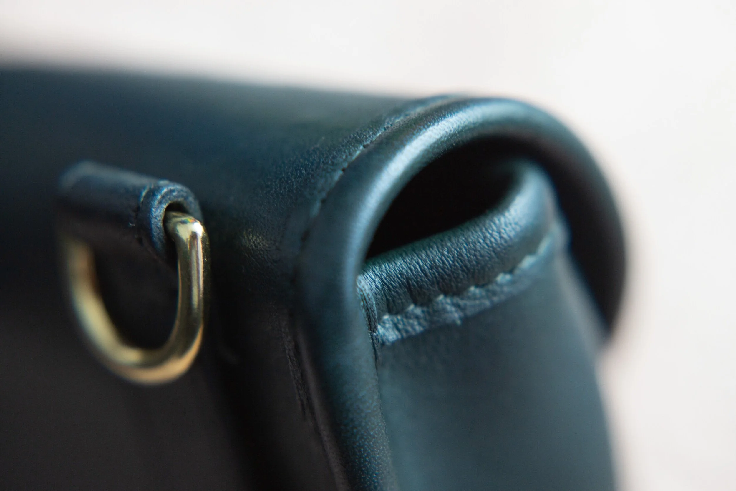 High-stress areas are reinforced with a strip of stitched down leather around entire length of bag