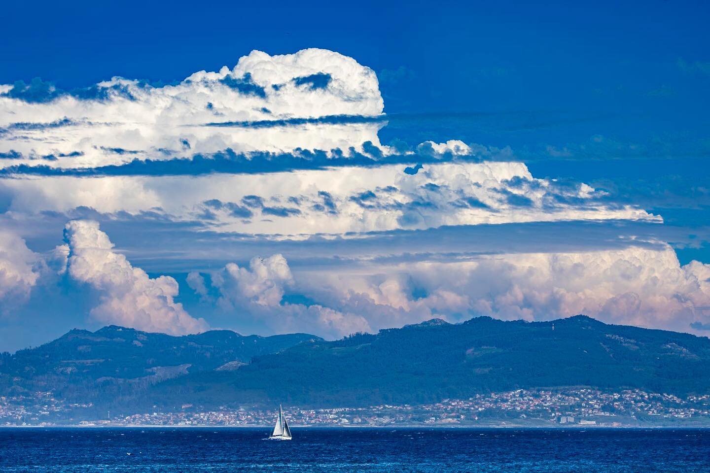 Summer storm clouds build above the mountains behind the city of Vigo in Galicia, Spain. 
.
.
. 
.
. 
@spain #galicia #muxia #spring #travel #sailing @travellerau #espa&ntilde;a #sailinglife #experiencegalicia #travellerau ⁠
#travelgram #wanderlust #