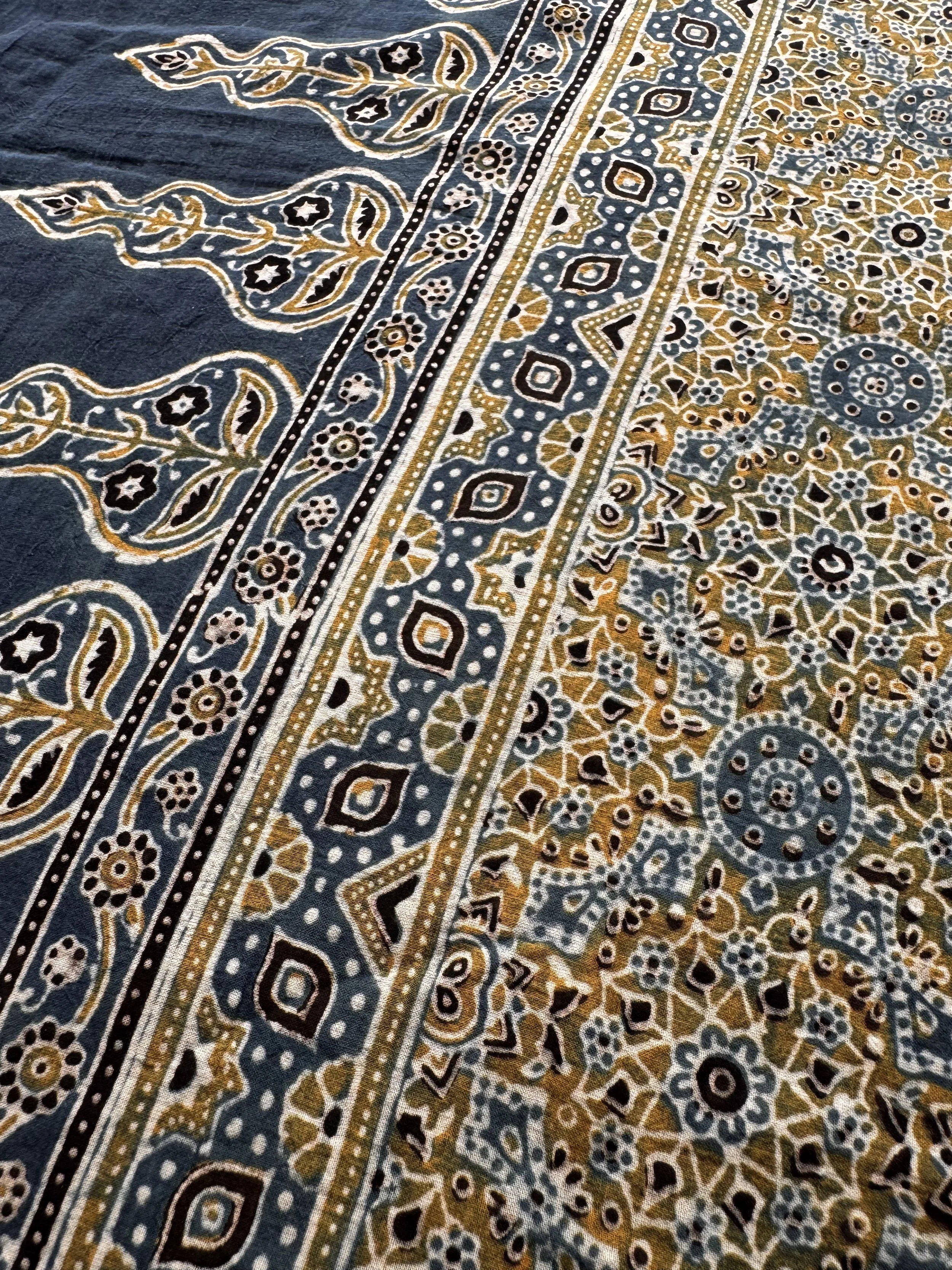 Flowing leaf and floral motifs on the deep indigo border of an Ajrakh cotton shawl
