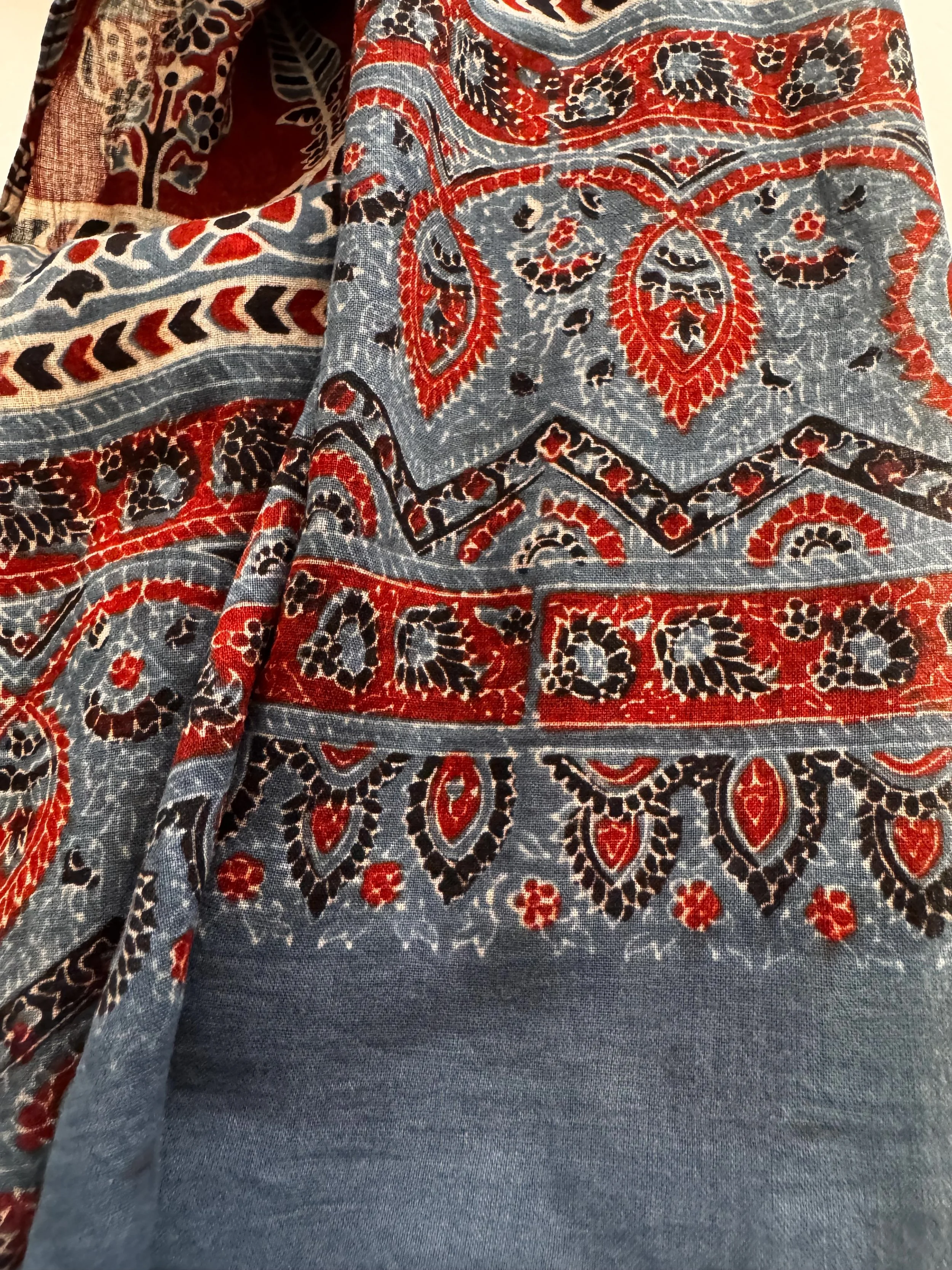 Detail of floral and geometric Ajrakh print in indigo, black and red on a handmade cotton scarf