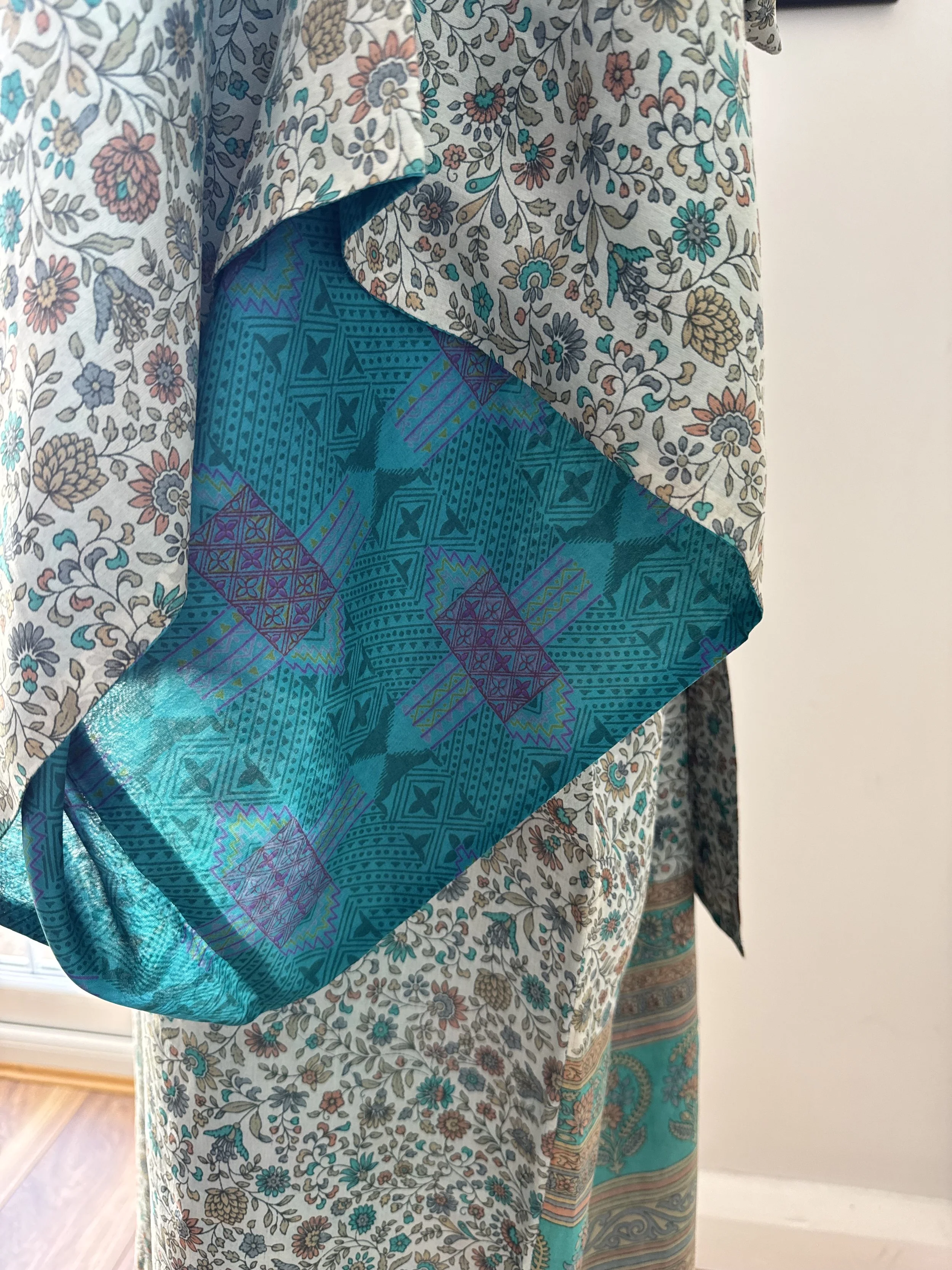 Close - up of traditional kimono sleeve on recycled sari silk robe, showing contrasting turquoise geometric lining