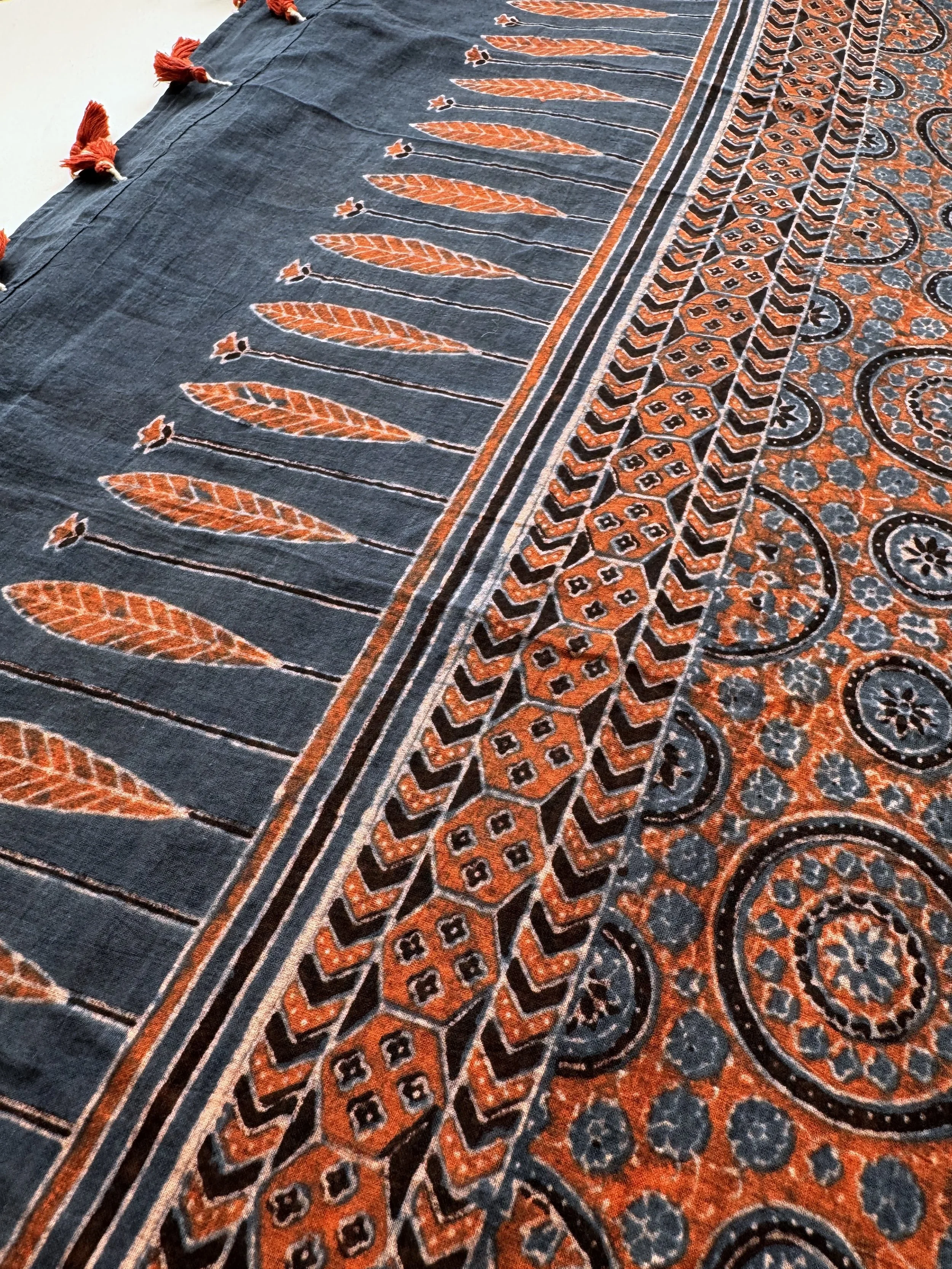Row of rust red leaf motifs on the indigo end of an Ajrakh block printed shawl