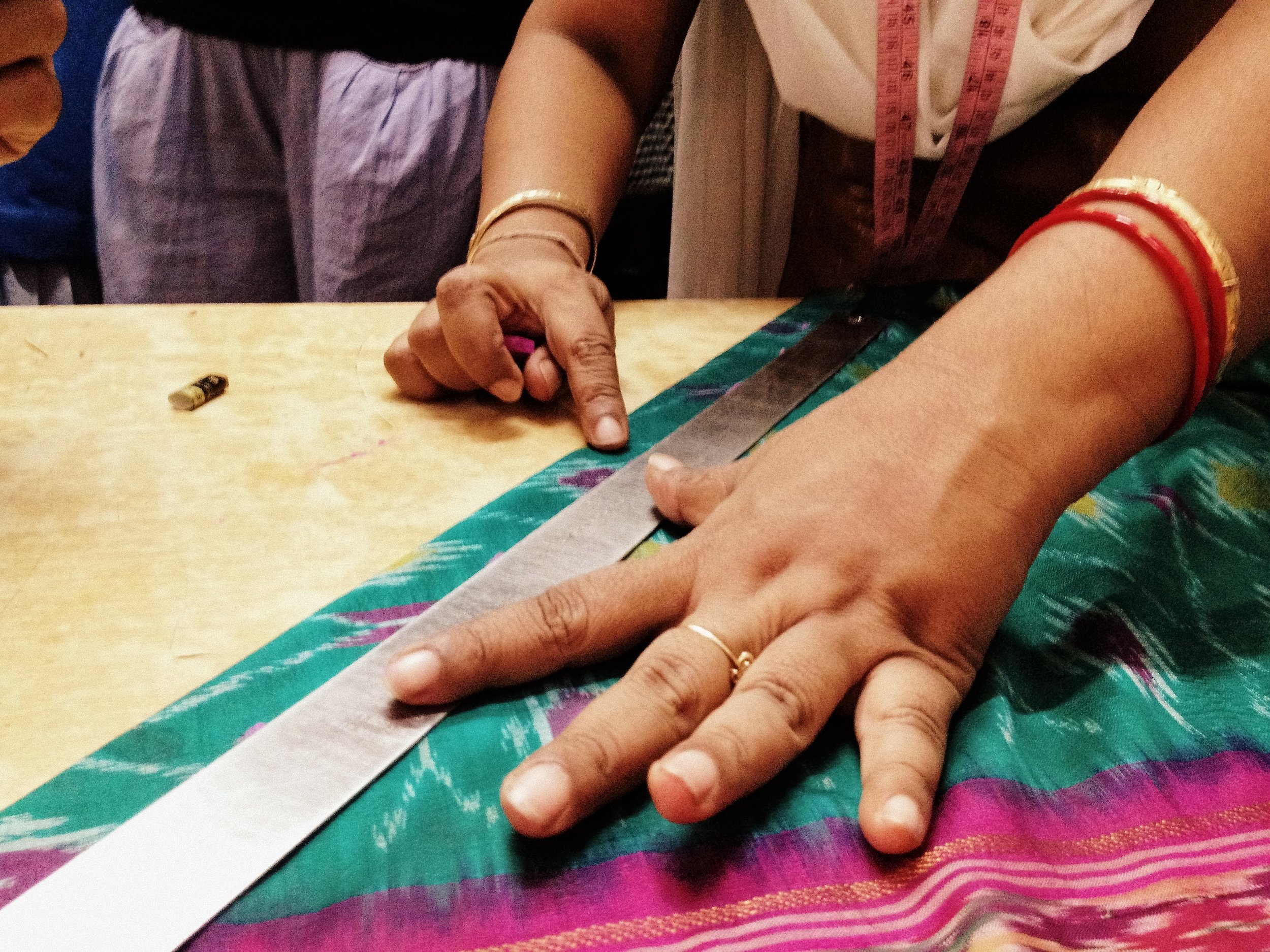 Sari being cut to size to make sari necklaces