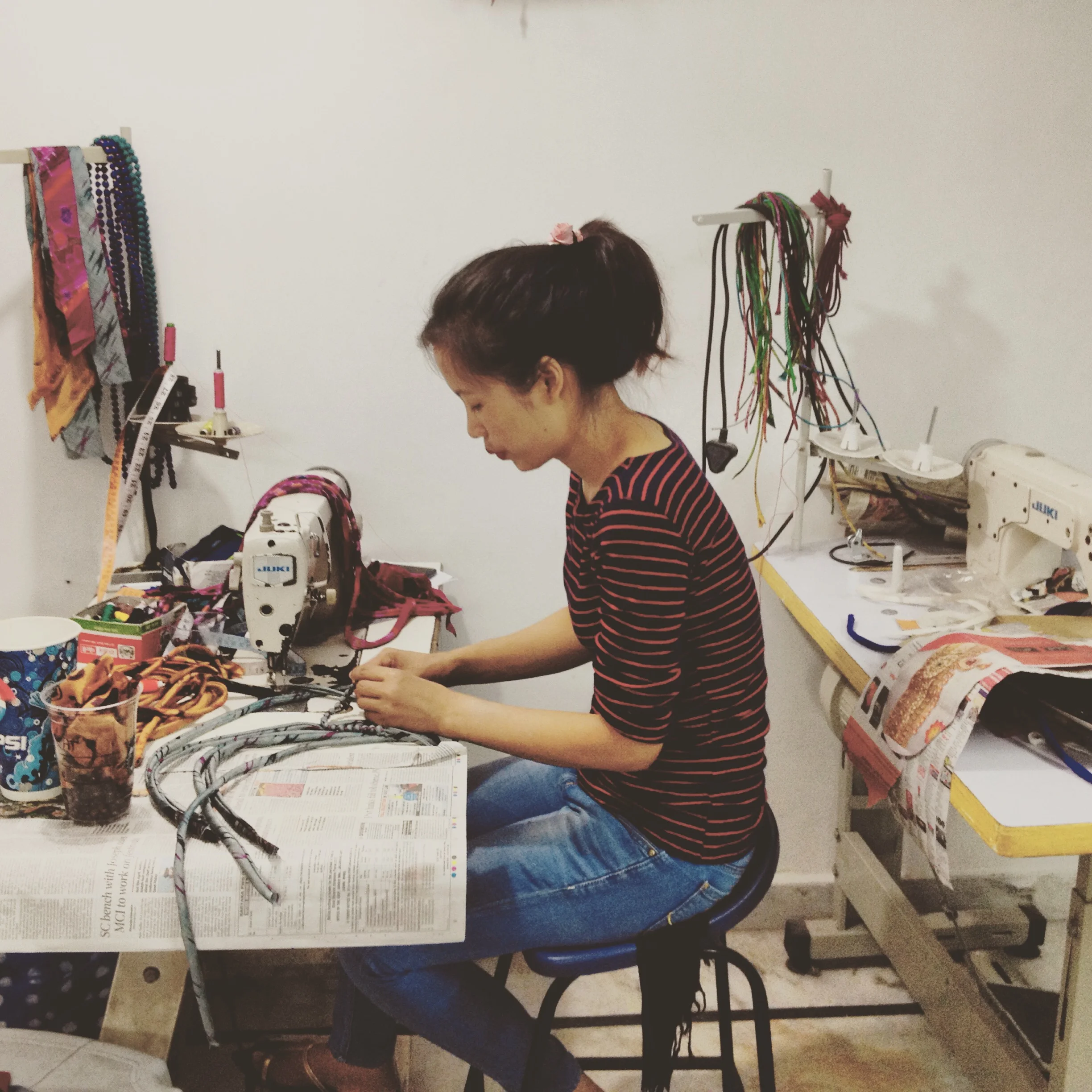 indian artisan seated making sari necklaces in front of sewing machine (Copy) (Copy) (Copy) (Copy) (Copy) (Copy) (Copy)