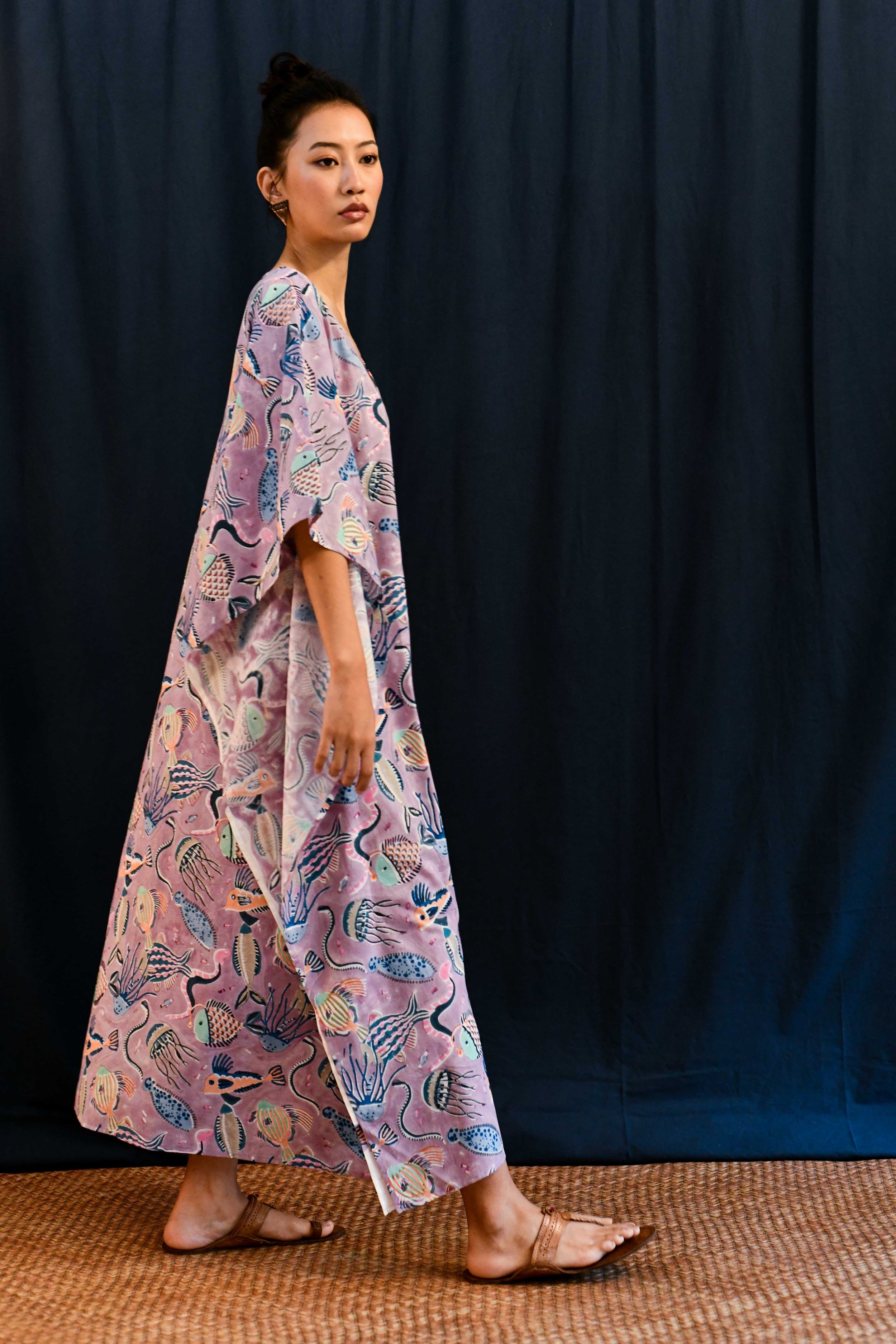 Side view of model wearing a lilac long kaftan dress with nautical images of sea life