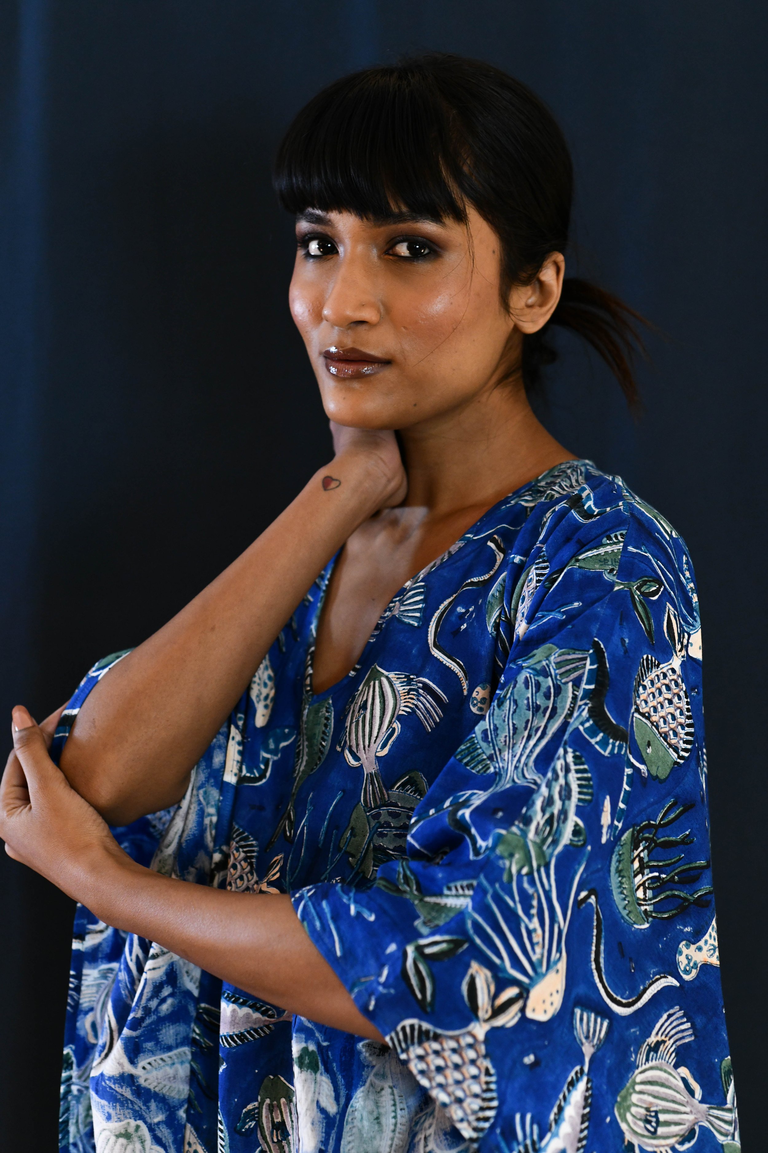 Model wearing ocean blue cotton kaftan with nautical images of sea life