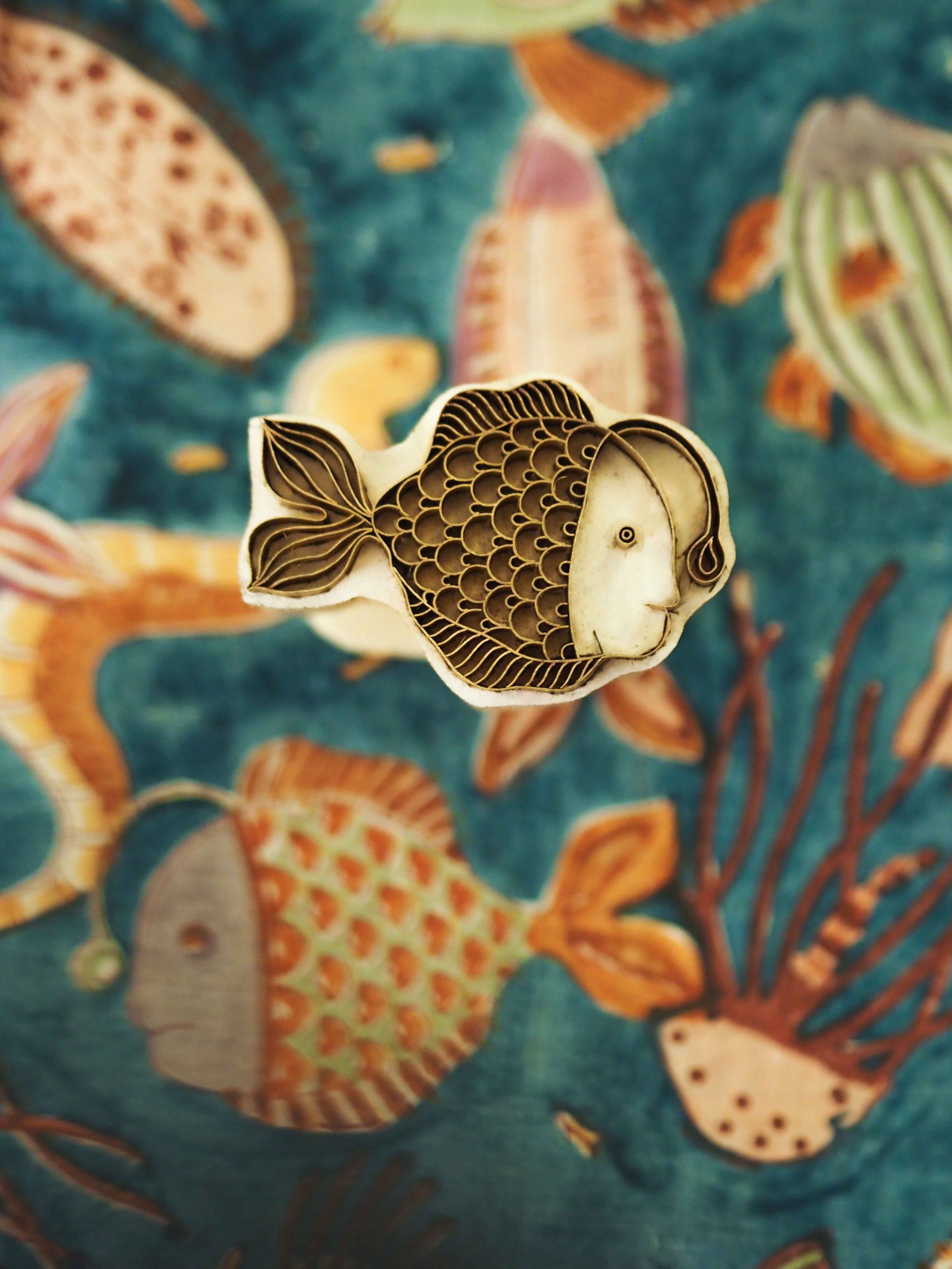 Quirky fish wooden carved block print with nautical print in background