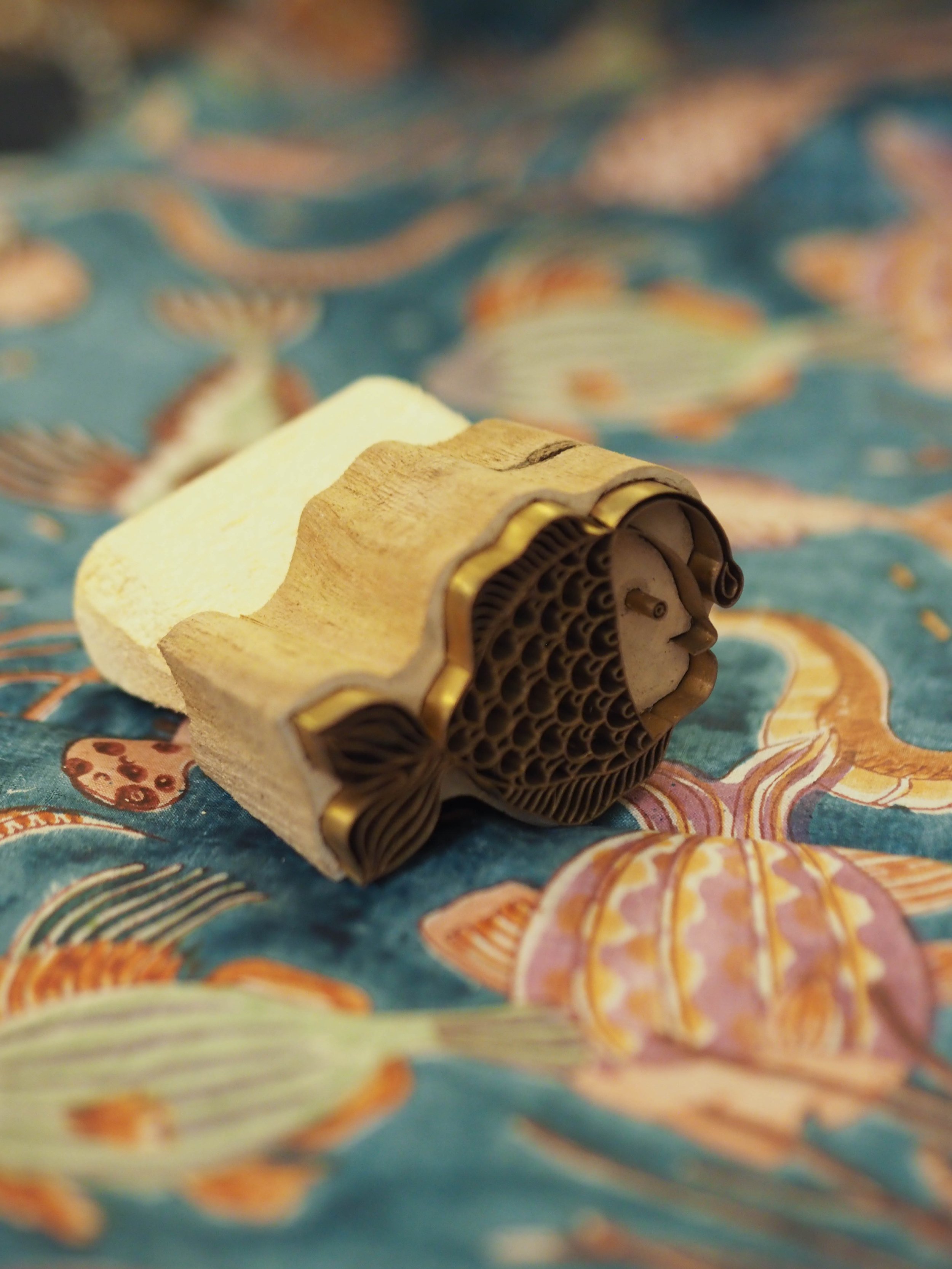 carved fish wooden block print on nautical background