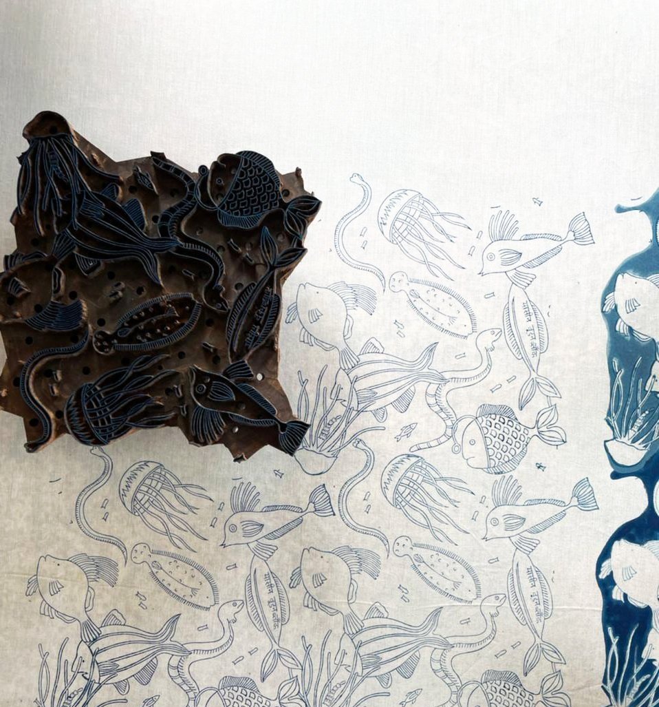 Carved wooden block next to nautical printed fabric
