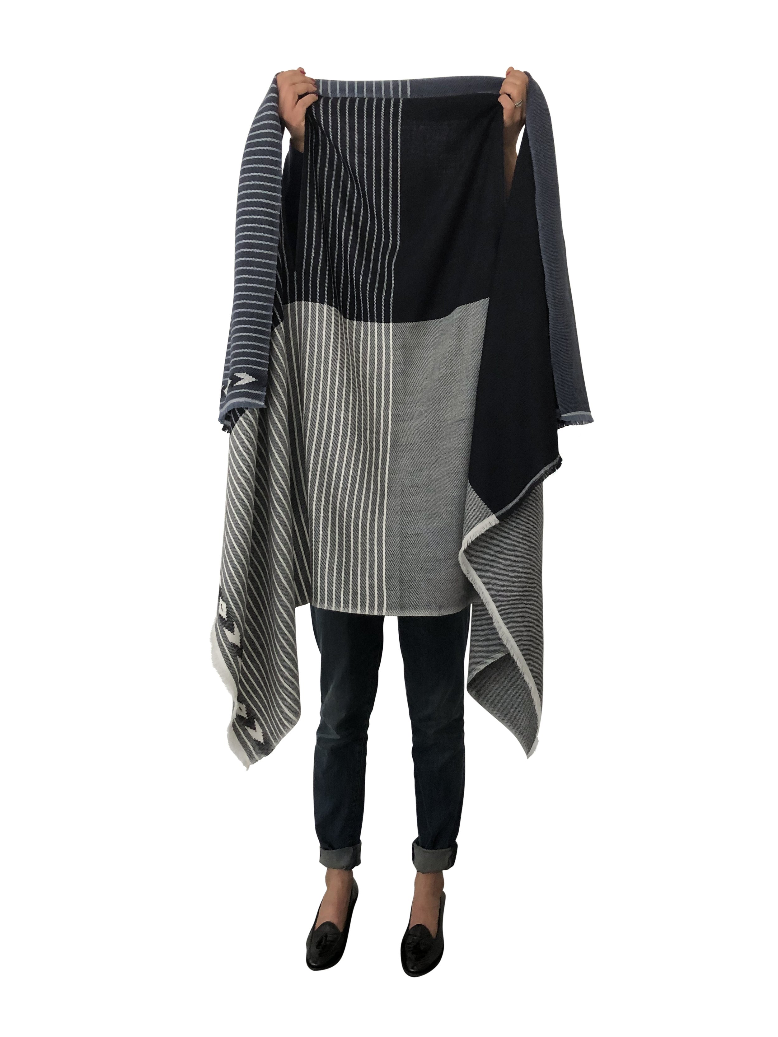 Person holding up a long striped black and white cape coat