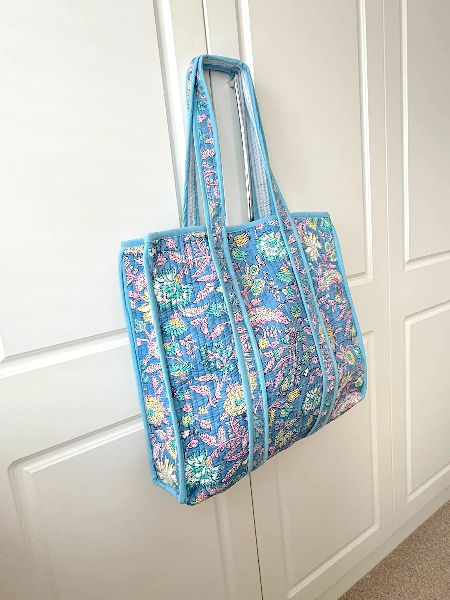Handmade block print quilted cotton tote bag in sky blue with intricate floral design by Jewelled Buddha