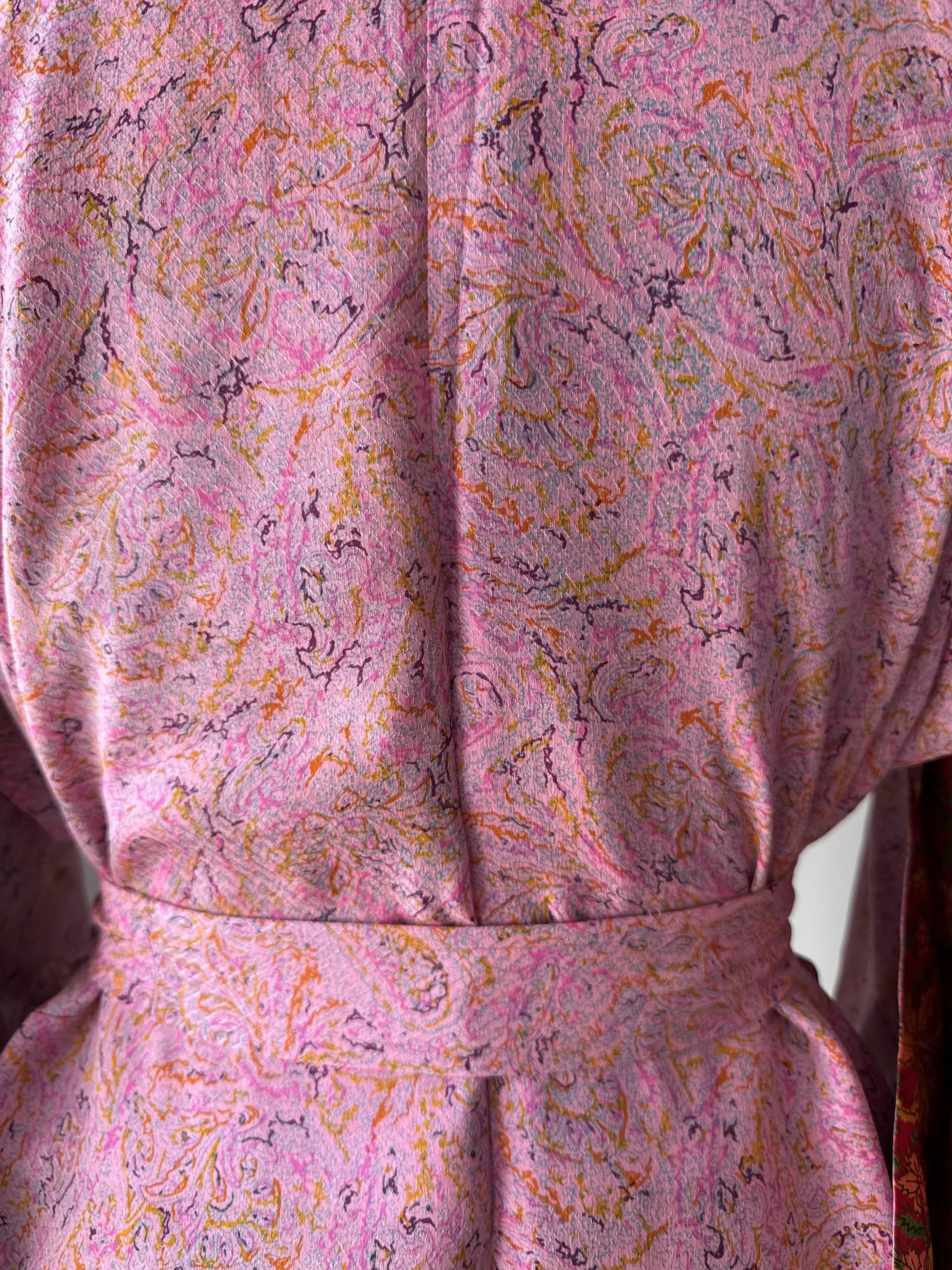 Close up of pink silk bathrobe handmade from recycled sari silk with paisley print