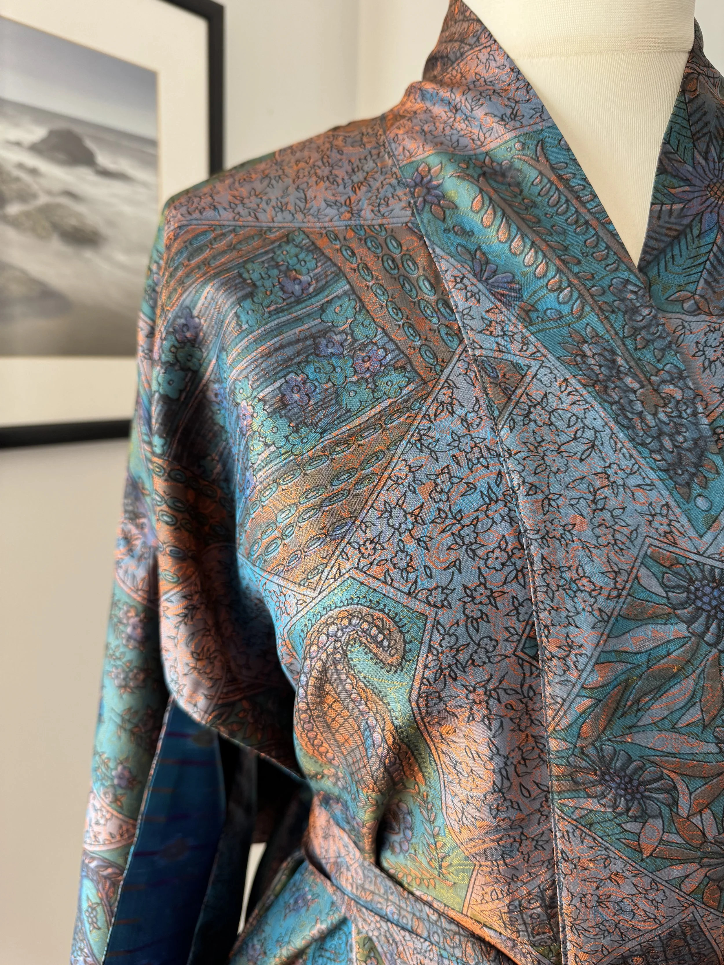 Close up of floral and paisley silk kimono robe in aubergine and teal, handmade in India