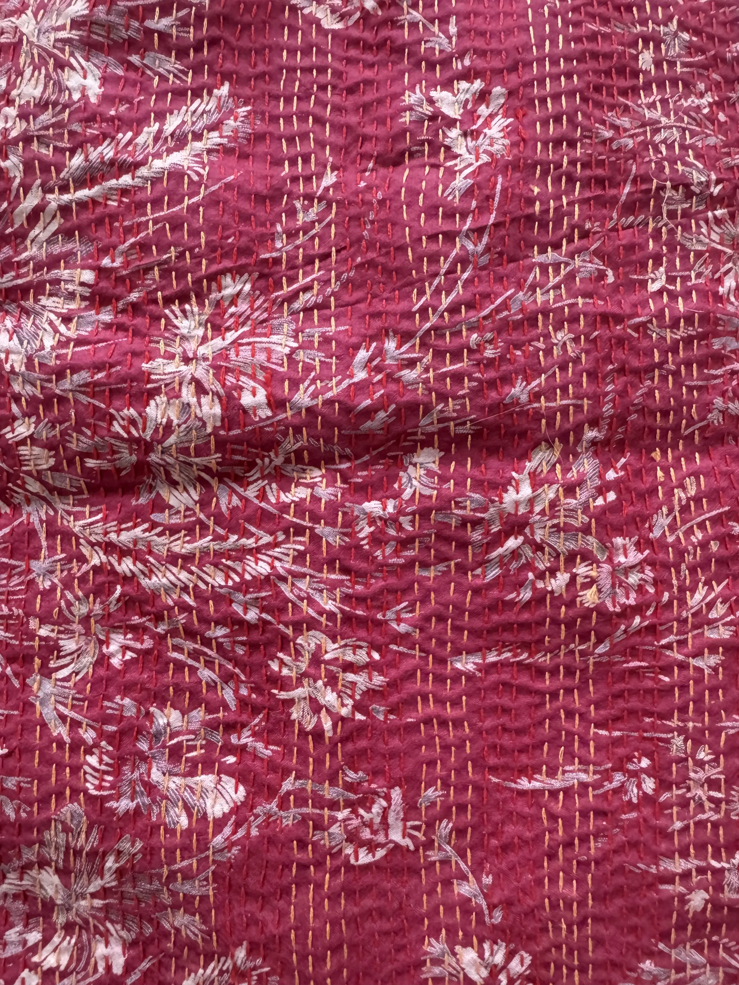 Close up upcycled sari silk fabric with floral print in raspberry pink.