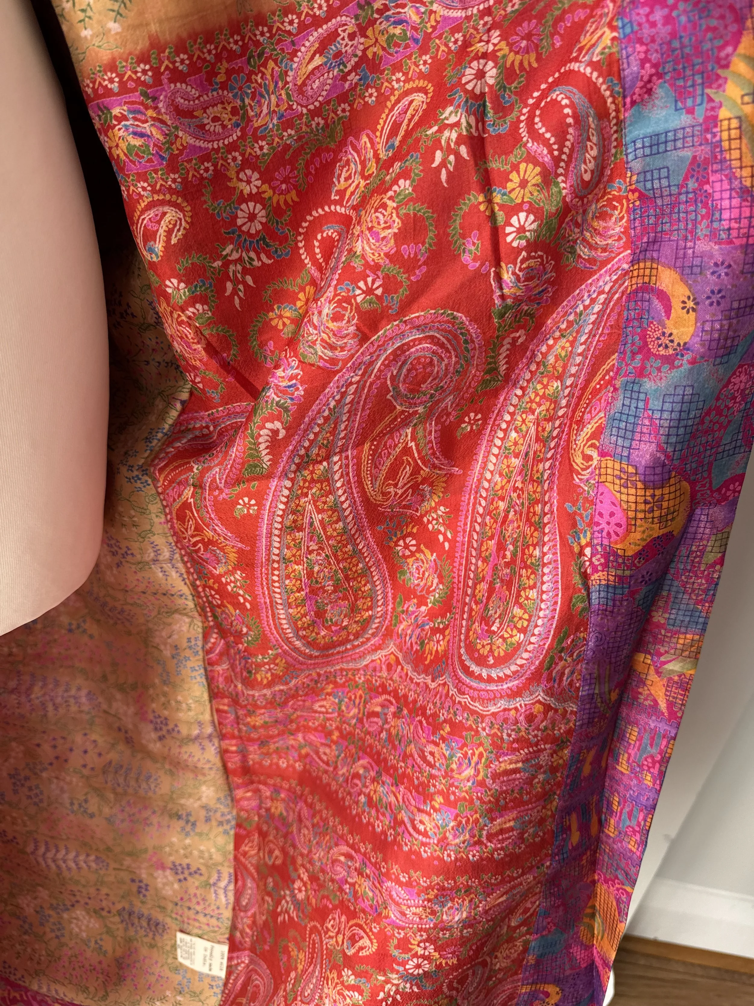 Detailed close up of silk kimono robe handmade from upcycled sari showing floral and paisley design in red