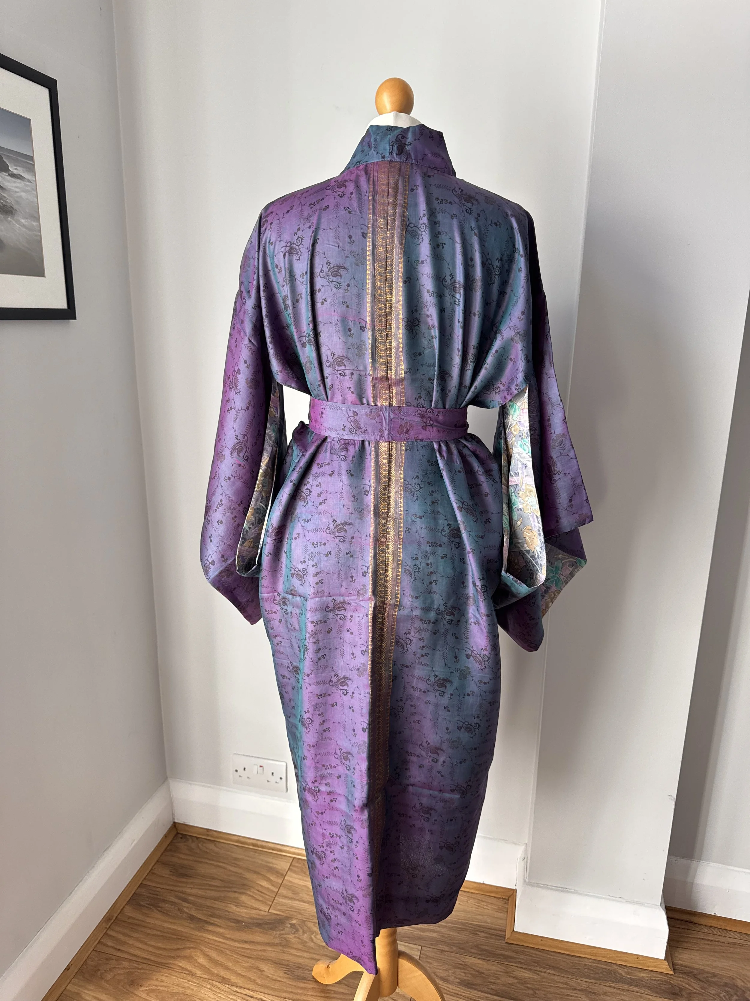 Back view of long silk kimono robe in two tone purple silk fabric with floral pattern and decorative gold strip down the back